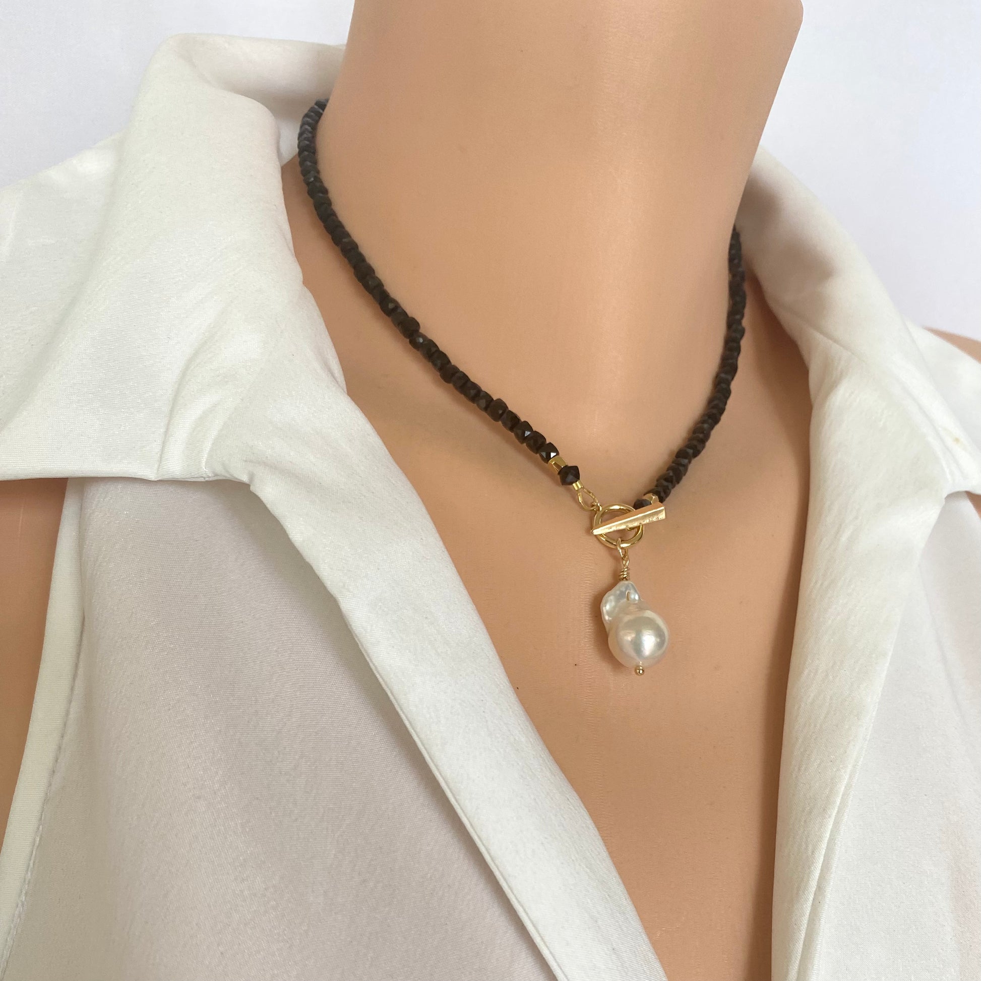 Black Tourmaline Choker Necklace with Pearl Charm showcasing sparkling faceted beads and gold clasp on a mannequin.