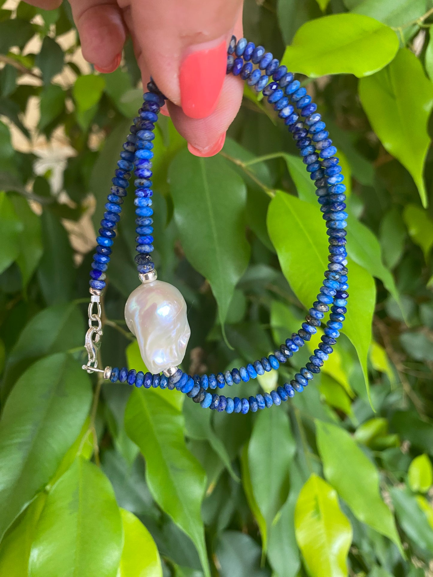 Lapis lazuli baroque pearl necklace featuring deep blue gemstone beads and a large freshwater pearl centerpiece.