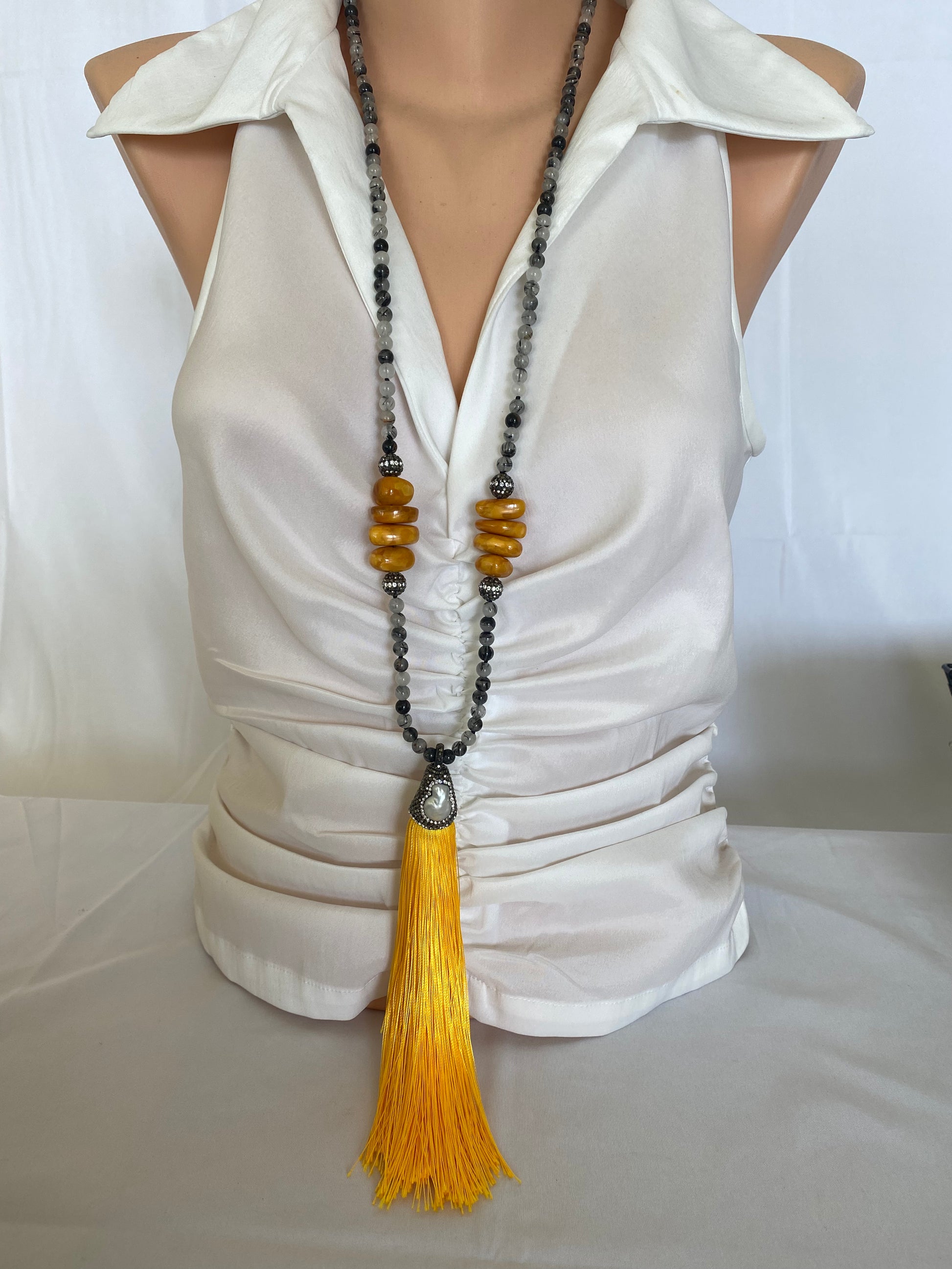 Rutilated quartz necklace with yellow silk tassel, boho style, medium shot on mannequin.