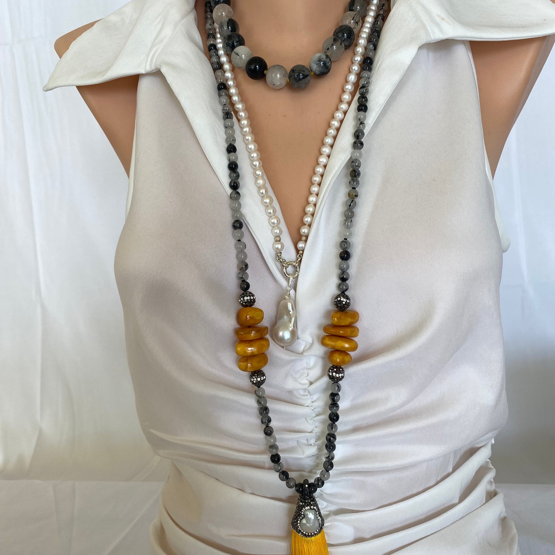 Yellow tassel rutilated quartz necklace on mannequin, handmade gemstone jewelry.