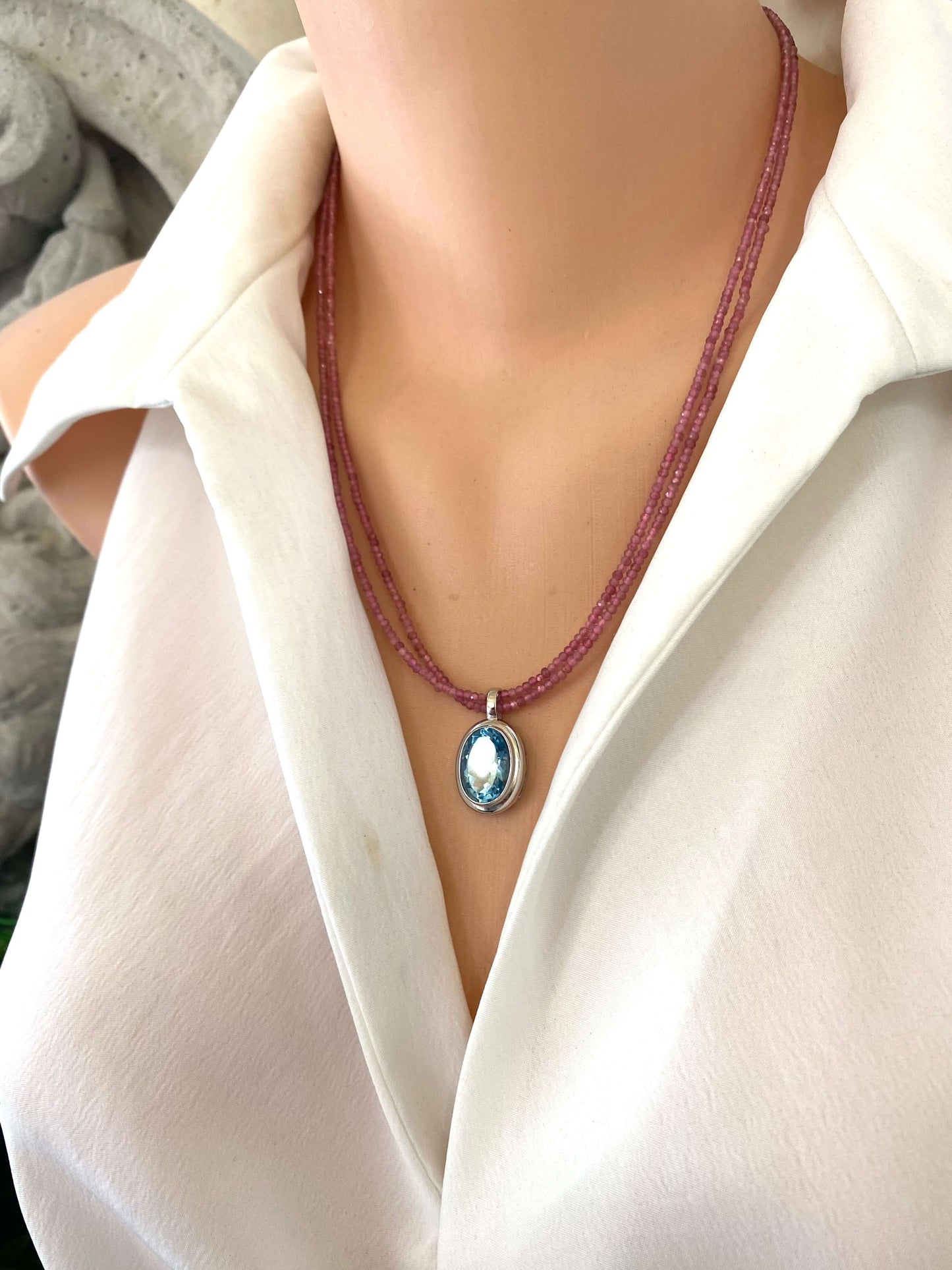 Pink Tourmaline Blue Topaz Pendant showcased on a mannequin wearing a white shirt with double strand design.