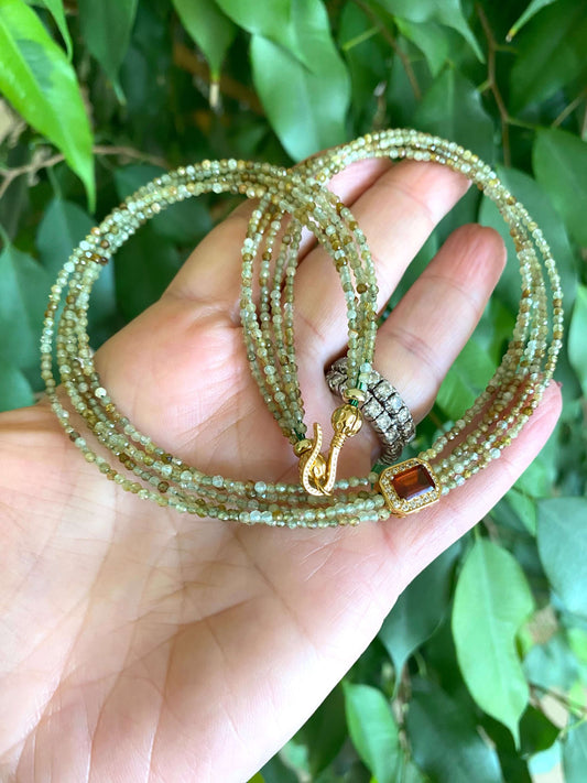 Green orange garnet necklace showcasing multi-strand gold vermeil with green garnet beads and orange garnet centerpiece.