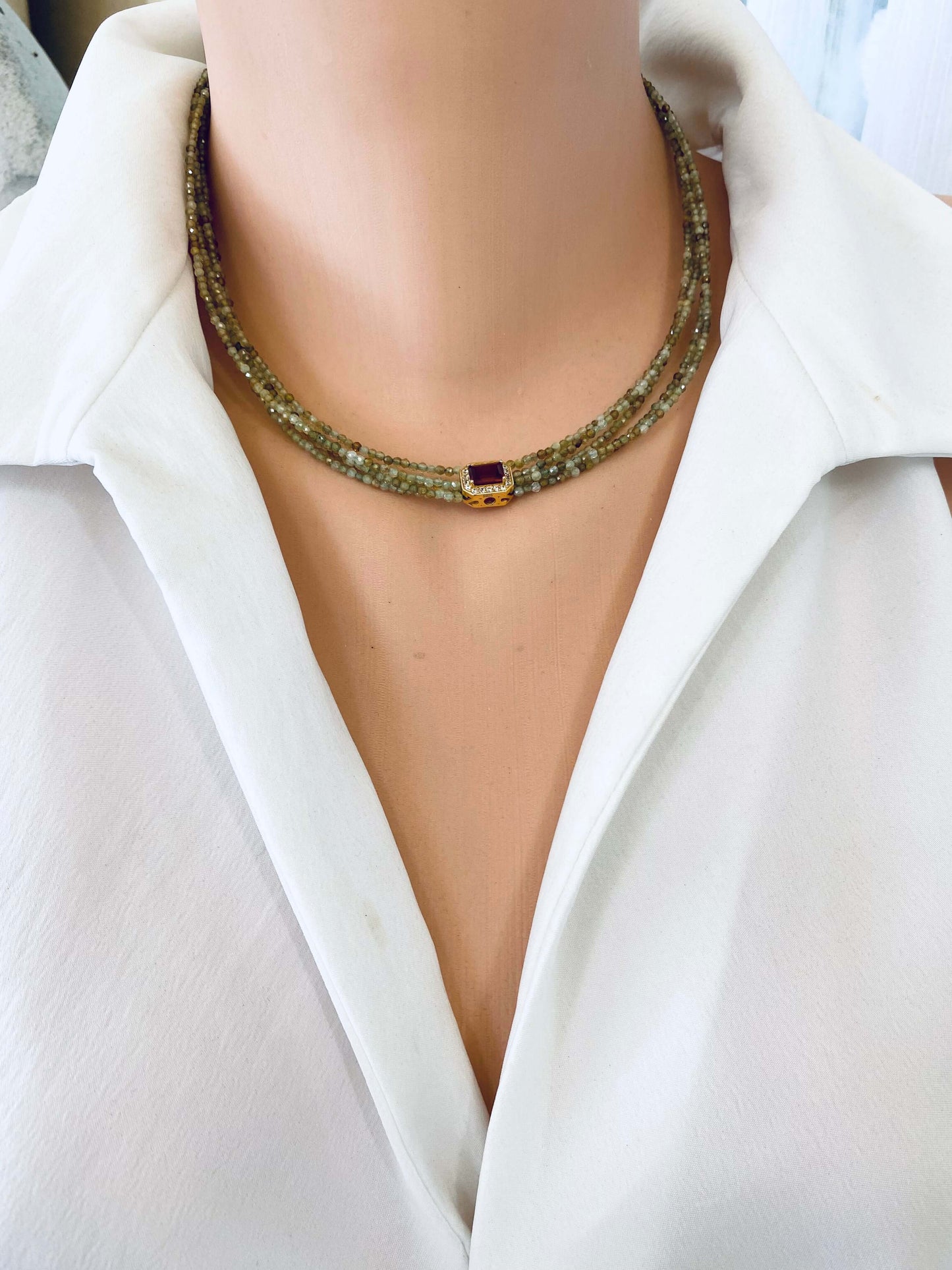 Green orange garnet necklace showcased on a mannequin with multi-strand gold vermeil design.