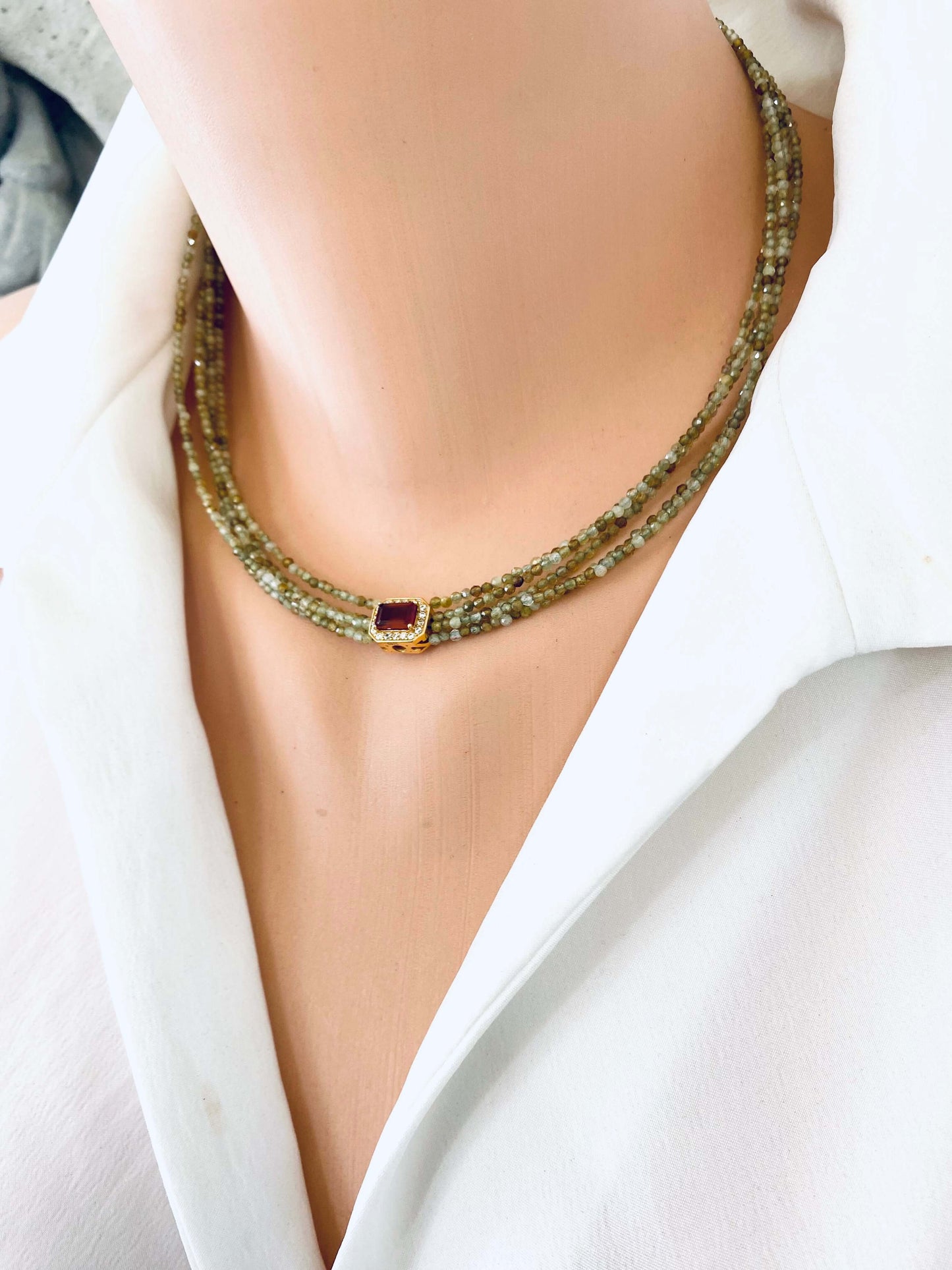 Green orange garnet necklace showcased on a mannequin, featuring multi-strand gold vermeil and vibrant gemstones.