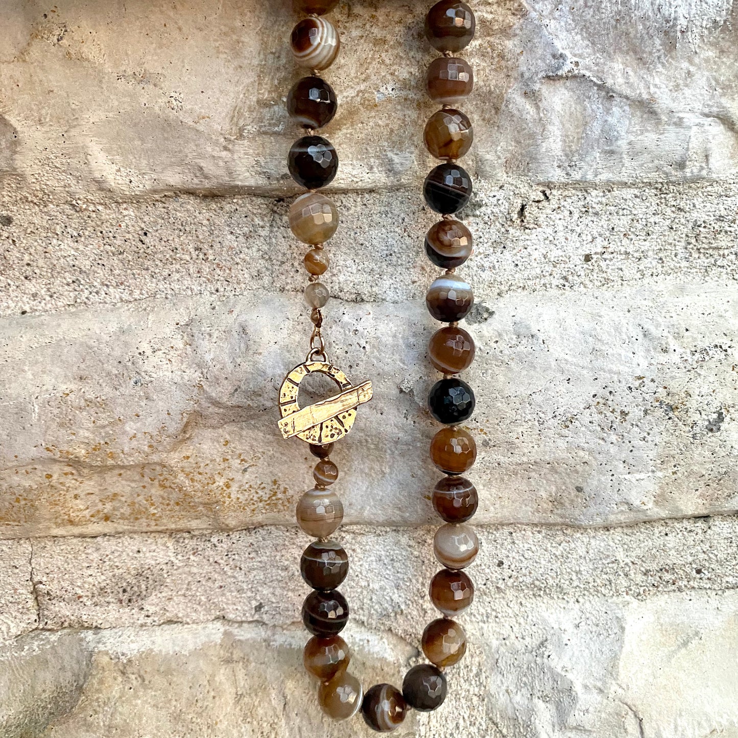 Botswana agate candy necklace with gold bronze details featuring chunky faceted beads and unique banding.