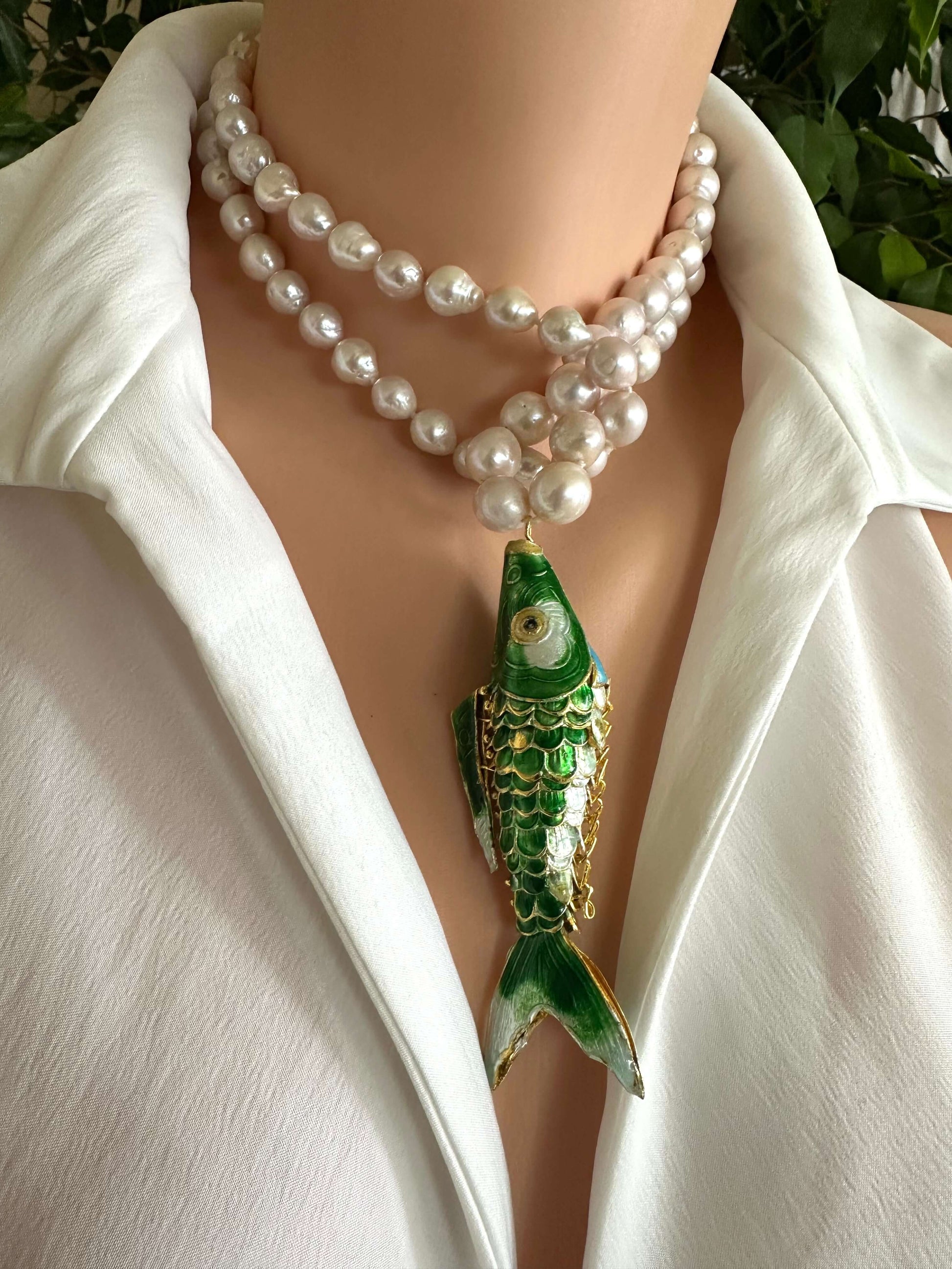 Cloisonné fish pearl necklace featuring green fish pendant and hand knotted baroque pearls on a mannequin.