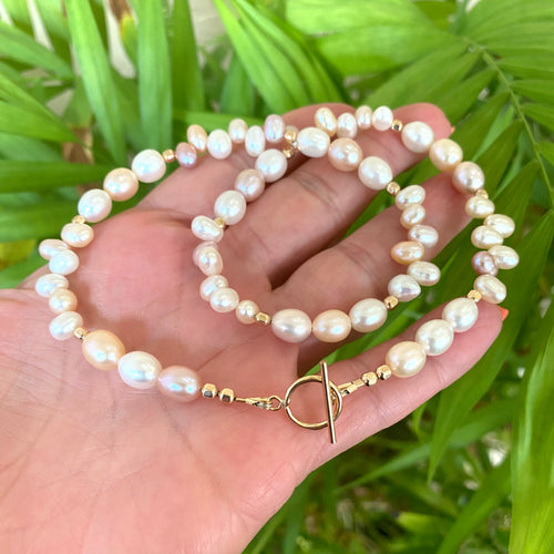 this choker necklace showcases the subtle shades of pink, lavender, peach, and cream, with a natural, lustrous glow. Enhanced and secured with gold filled beads and toggle clasp. Measures 16