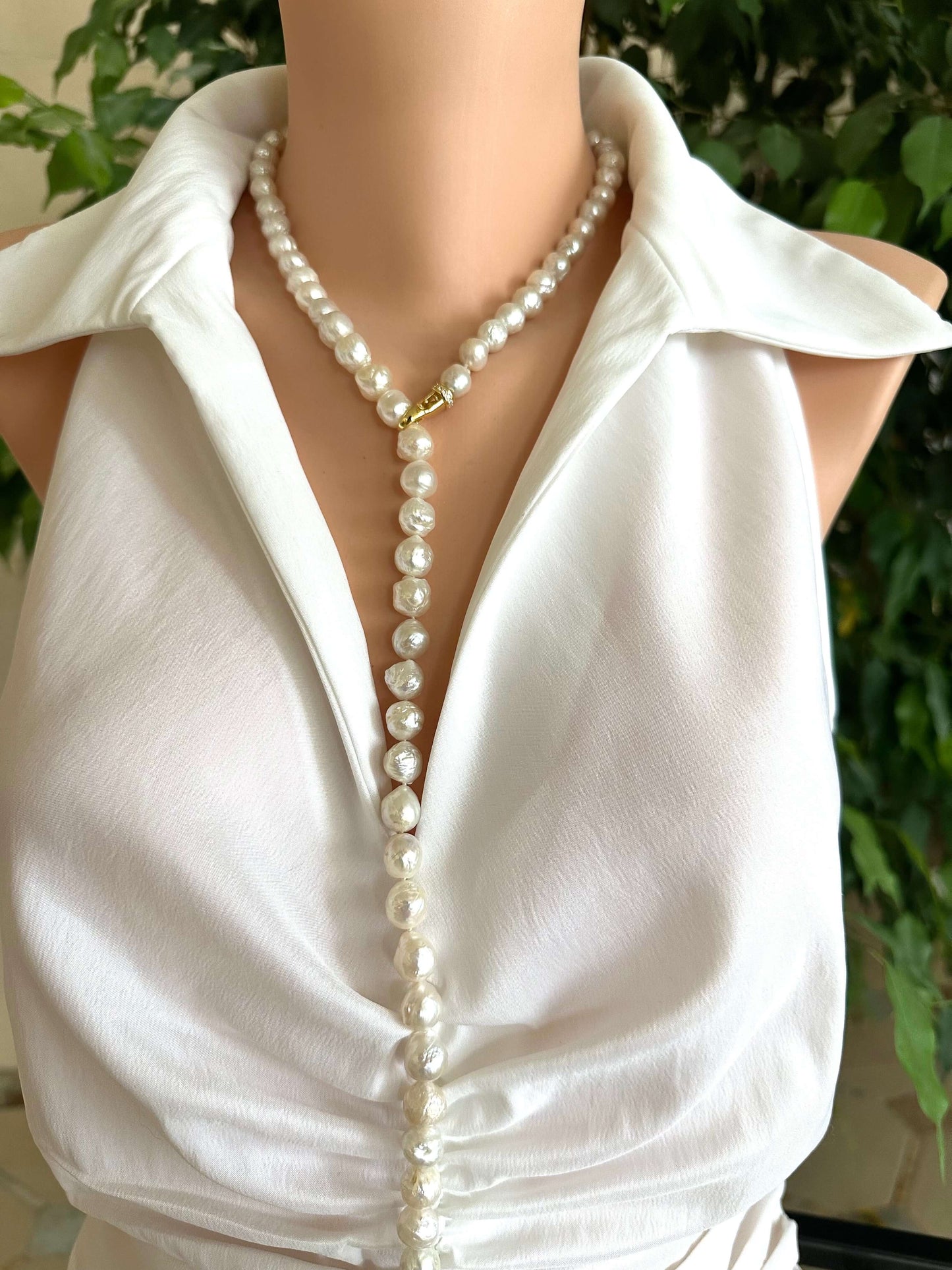 Edison pearl Y necklace with baroque pearls worn on a white blouse, showcasing its elegant design and versatility.