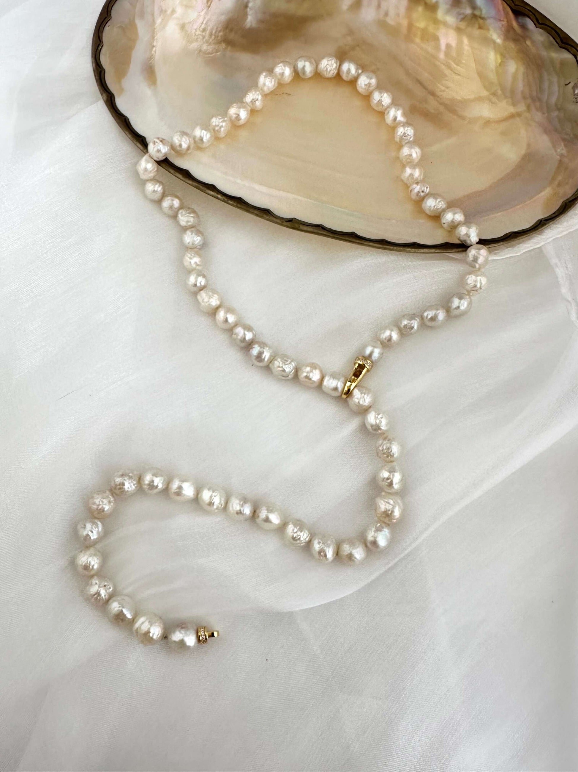 Edison pearl Y necklace featuring white avocado baroque pearls elegantly displayed on a delicate background.