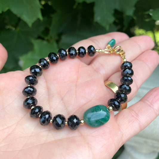 Spinel emerald bracelet showcasing black spinel beads and a green emerald centerpiece, highlighting elegant craftsmanship.