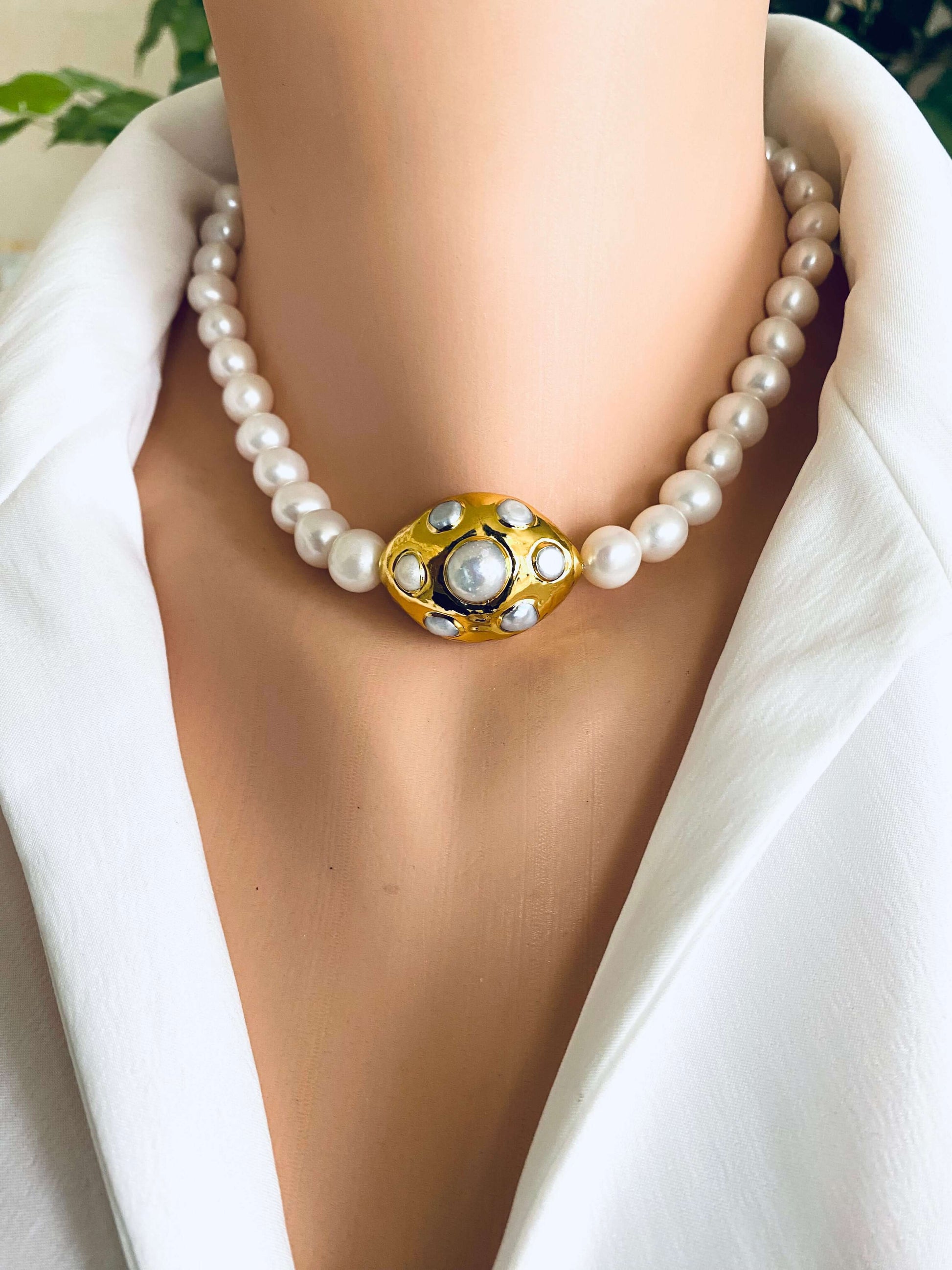 White potato pearl necklace with gold focal accent showcased on a mannequin bust.