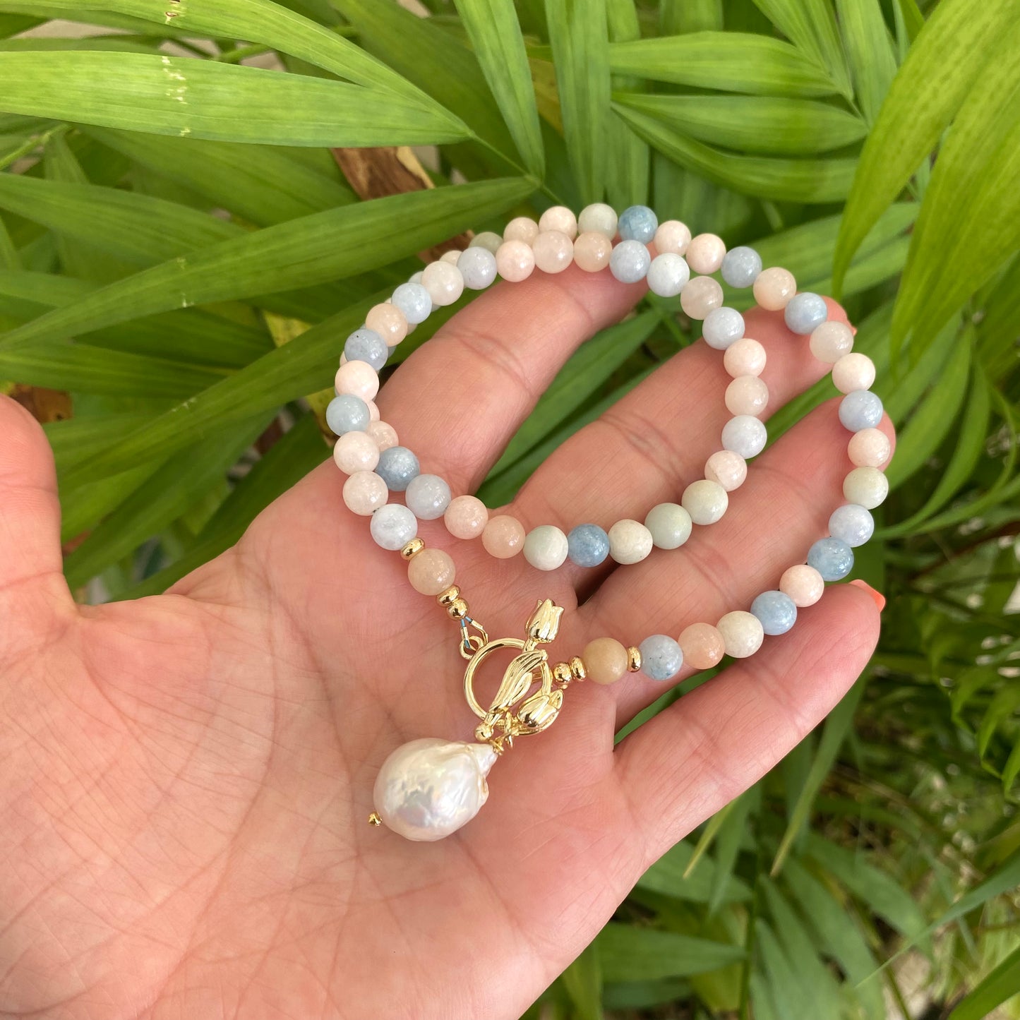 Morganite aquamarine pearl necklace held in hand with baroque pearl pendant, handmade Canadian jewelry