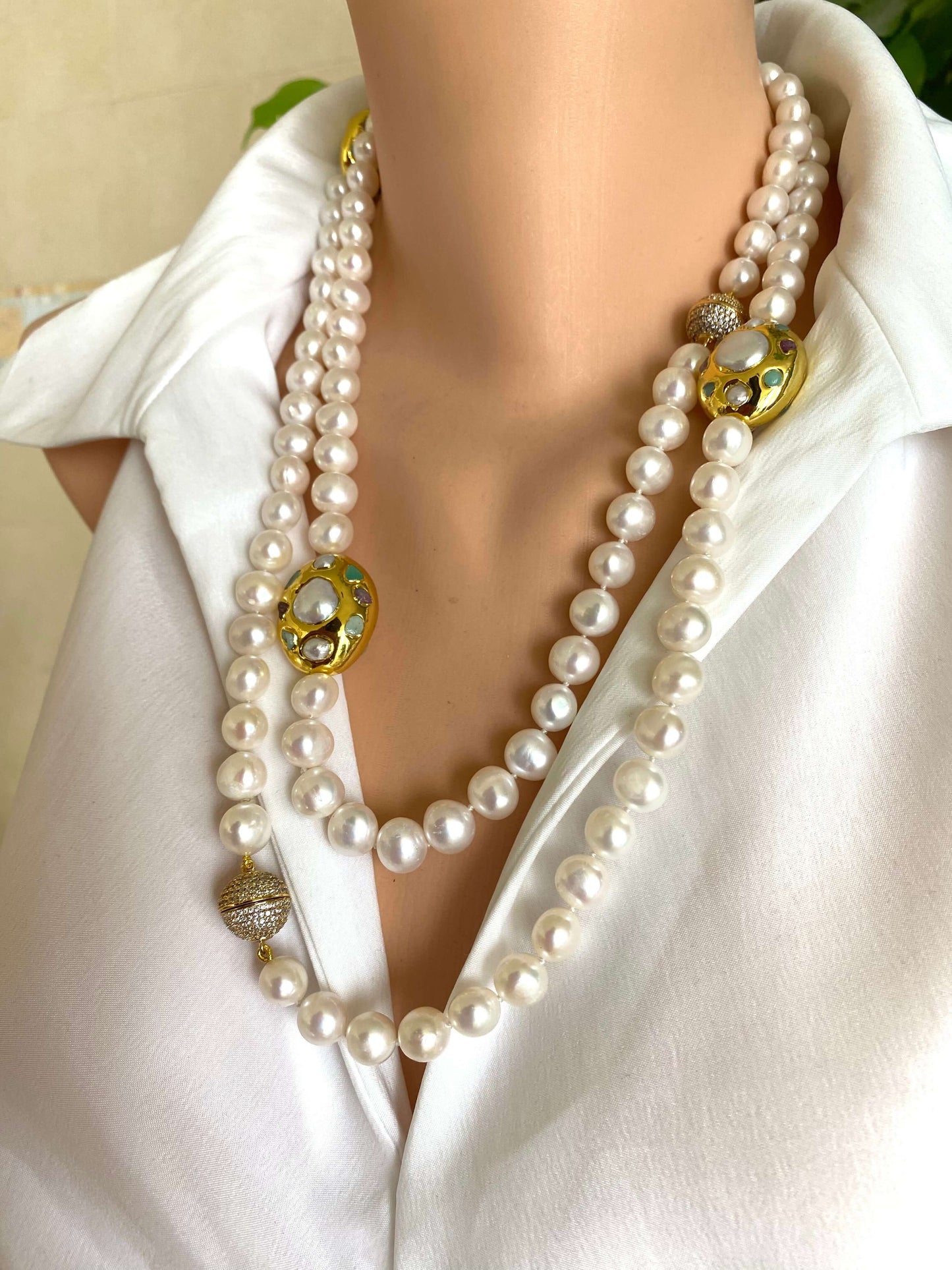 White pearl necklace with gold accent worn on a mannequin, showcasing elegant freshwater pearls and gold focal accents.