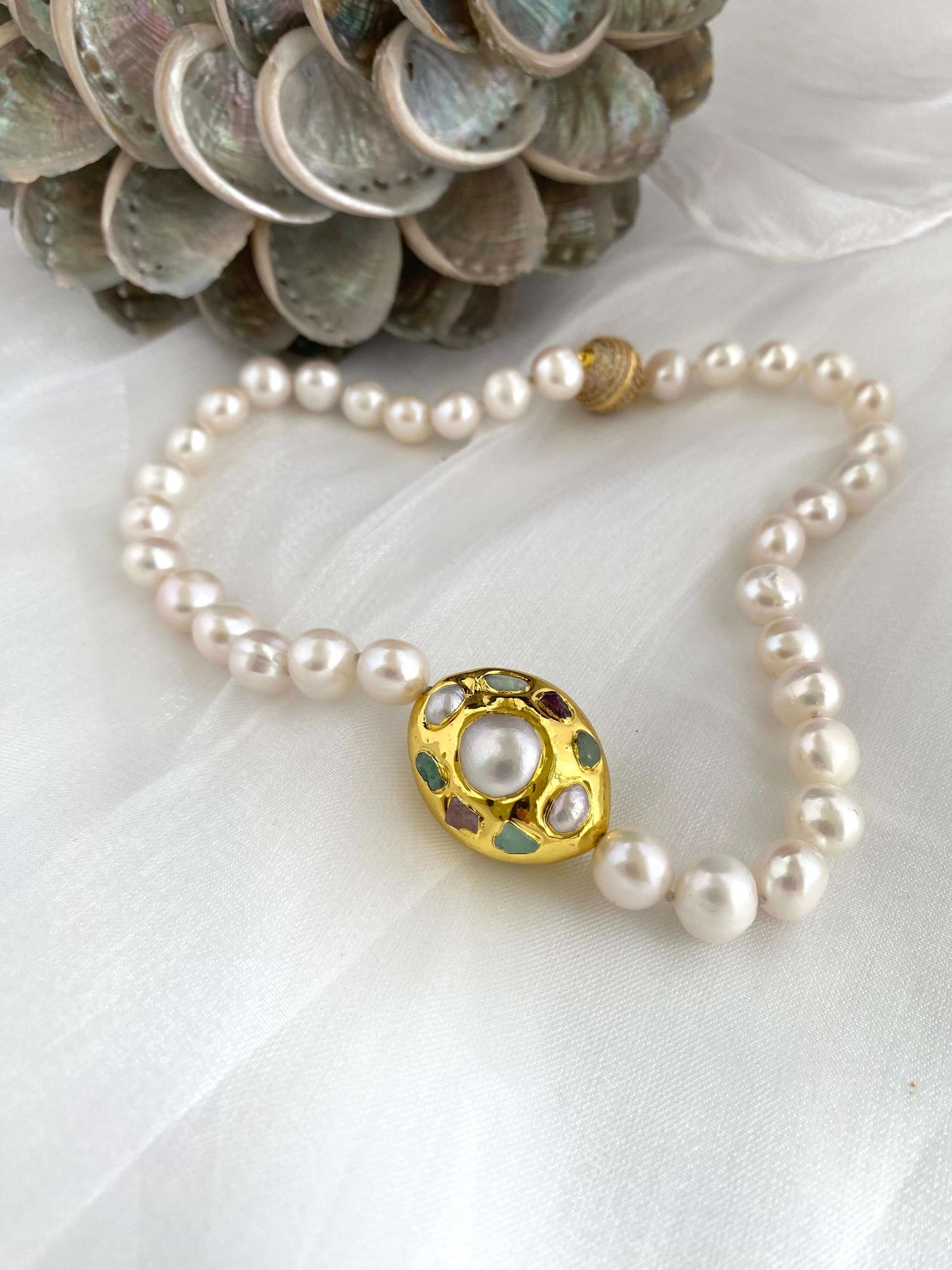 White pearl necklace with gold accent featuring freshwater pearls and a decorative gold focal accent.