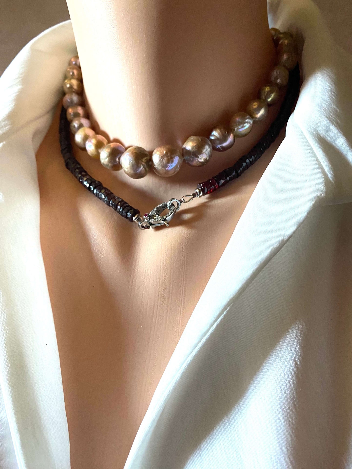 Garnet beaded necklace with diamond and ruby pavé clasp displayed elegantly on a mannequin neck.