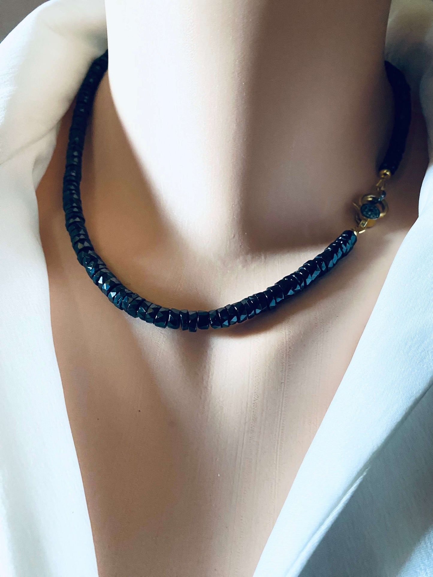 Black spinel beaded necklace with gold vermeil pavé clasp showcased on a mannequin.