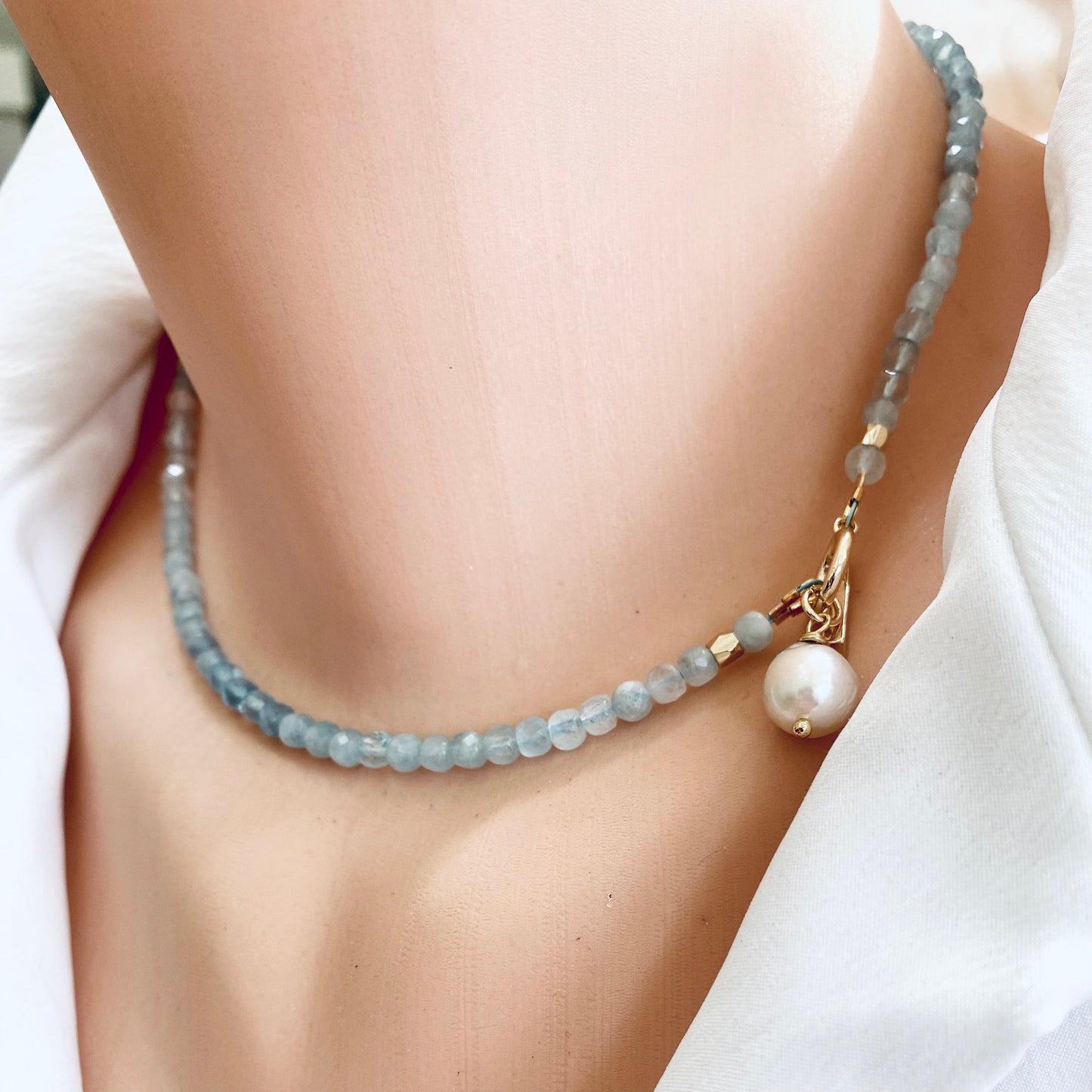Aquamarine toggle necklace with baroque pearl pendant displayed on a mannequin's neck, showcasing its elegant design.
