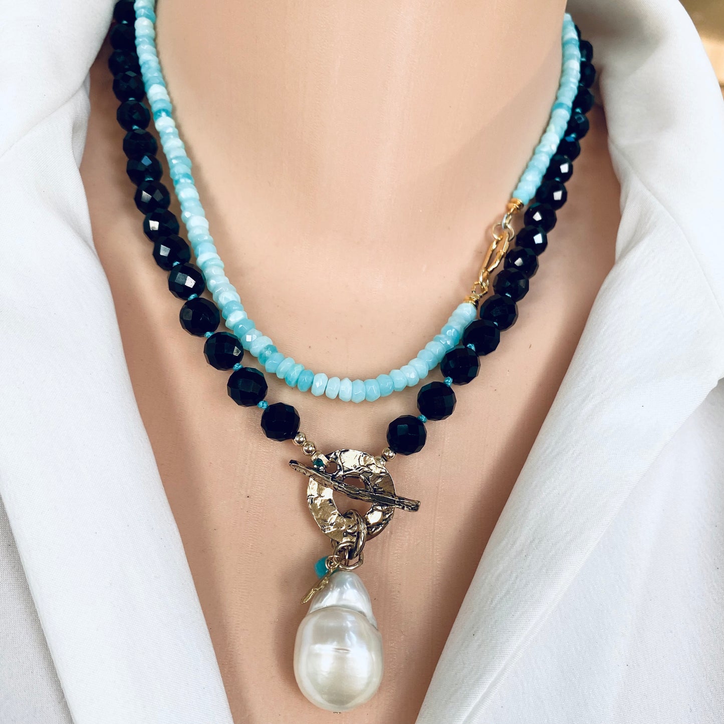 Black tourmaline baroque pearl toggle necklace close-up showing hamsa charm and amazonite accent