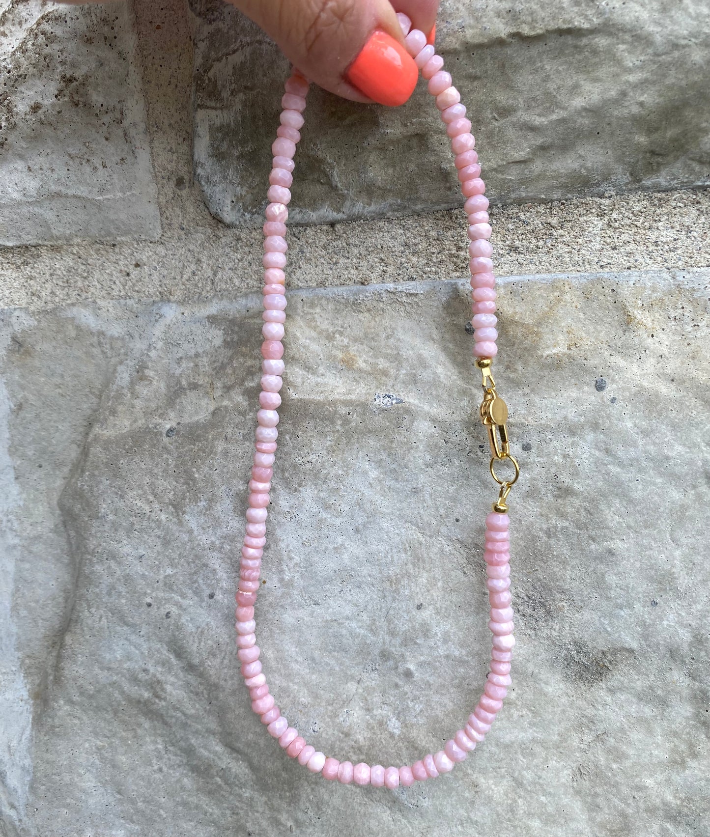 Pink opal short necklace displayed flat showing bead spacing and gold clasp detail