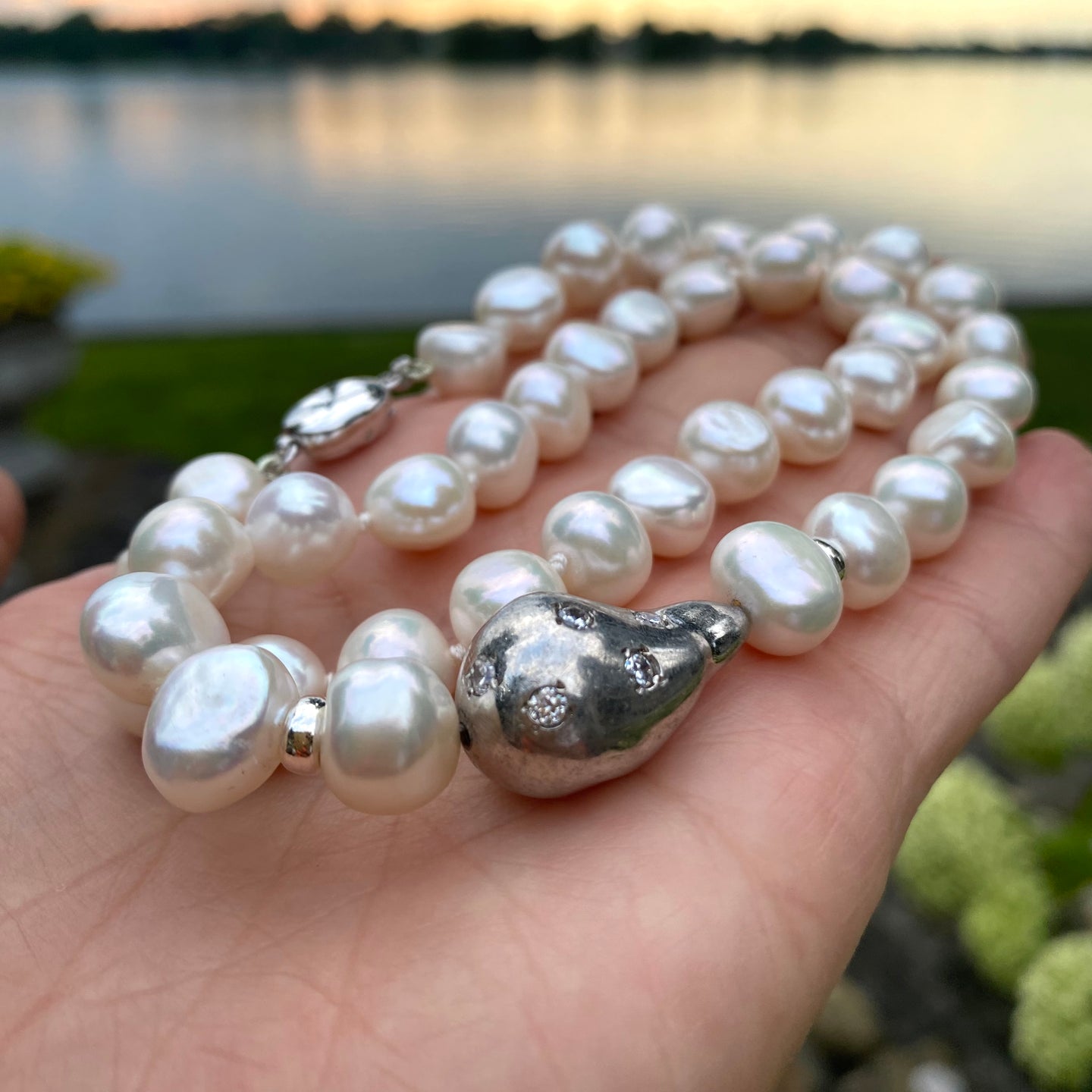 hand-knotted Classic Bridal White Pearl Necklace adorned with a stunning white zircons pave baroque pearl-like sterling silver element at the side. It measures 18 inches in length and is secured with a sterling silver box clasp for convenient wear.