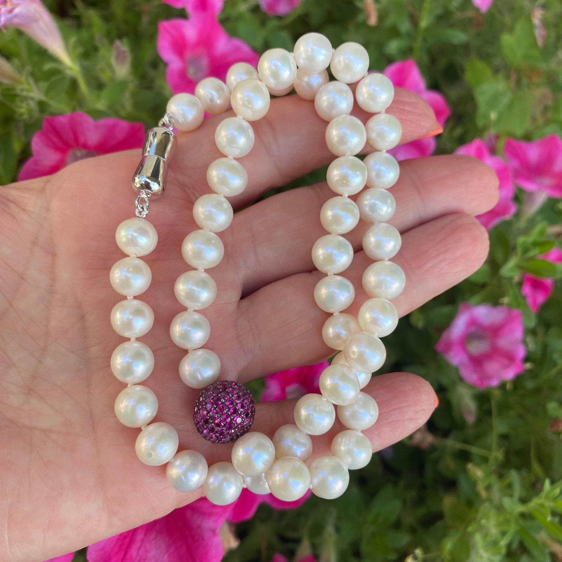 pearl necklace with ruby red CZ bead, handmade in Canada, featuring lustrous freshwater pearls and sterling-silver clasp.