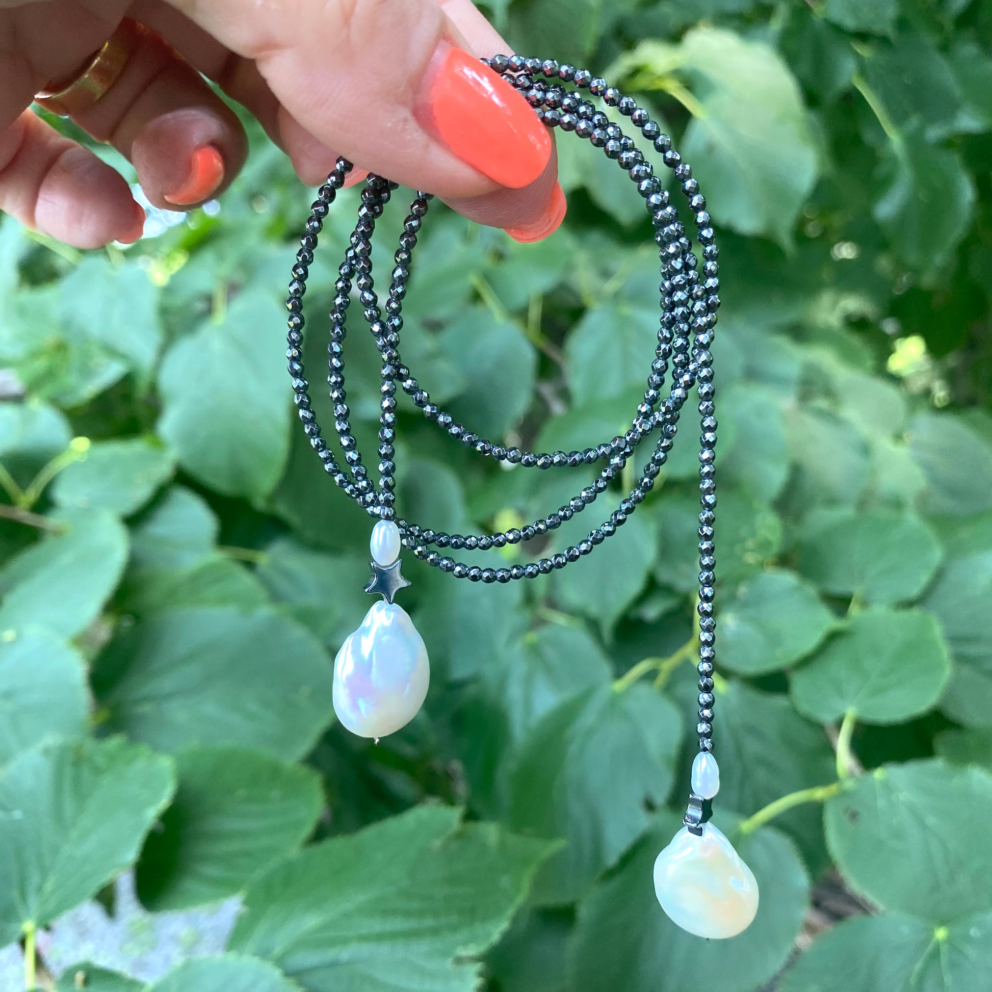Hematite baroque pearl lariat necklace photographed outdoors emphasizing adjustable open ends