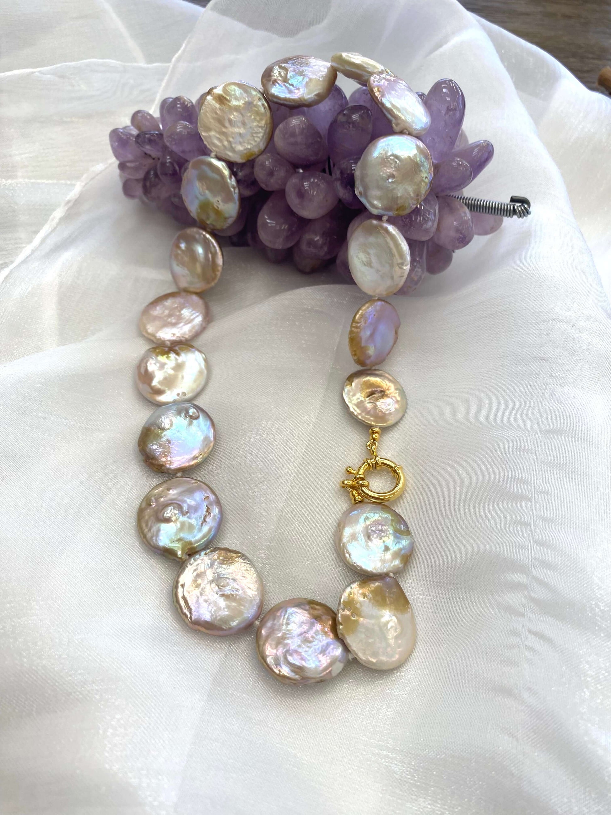 Large coin pearl necklace close up on white background showing pearl texture