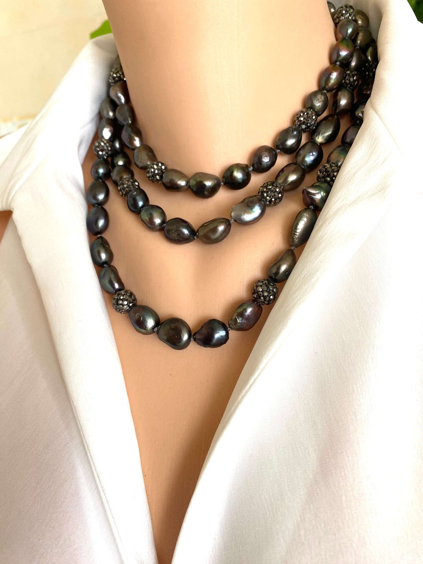 Black beaded necklace on a mannequin with a white background