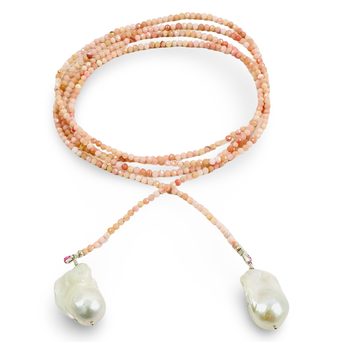 A longi-strand beaded necklace with small peach, pink, and cream beads, featuring two large irregular white baroque pearls at the ends, displayed on a clean white background.
