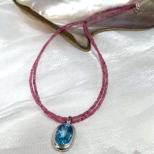 Pink Tourmaline Blue Topaz Pendant on double-strand necklace, showcasing vibrant pink and blue gemstones.