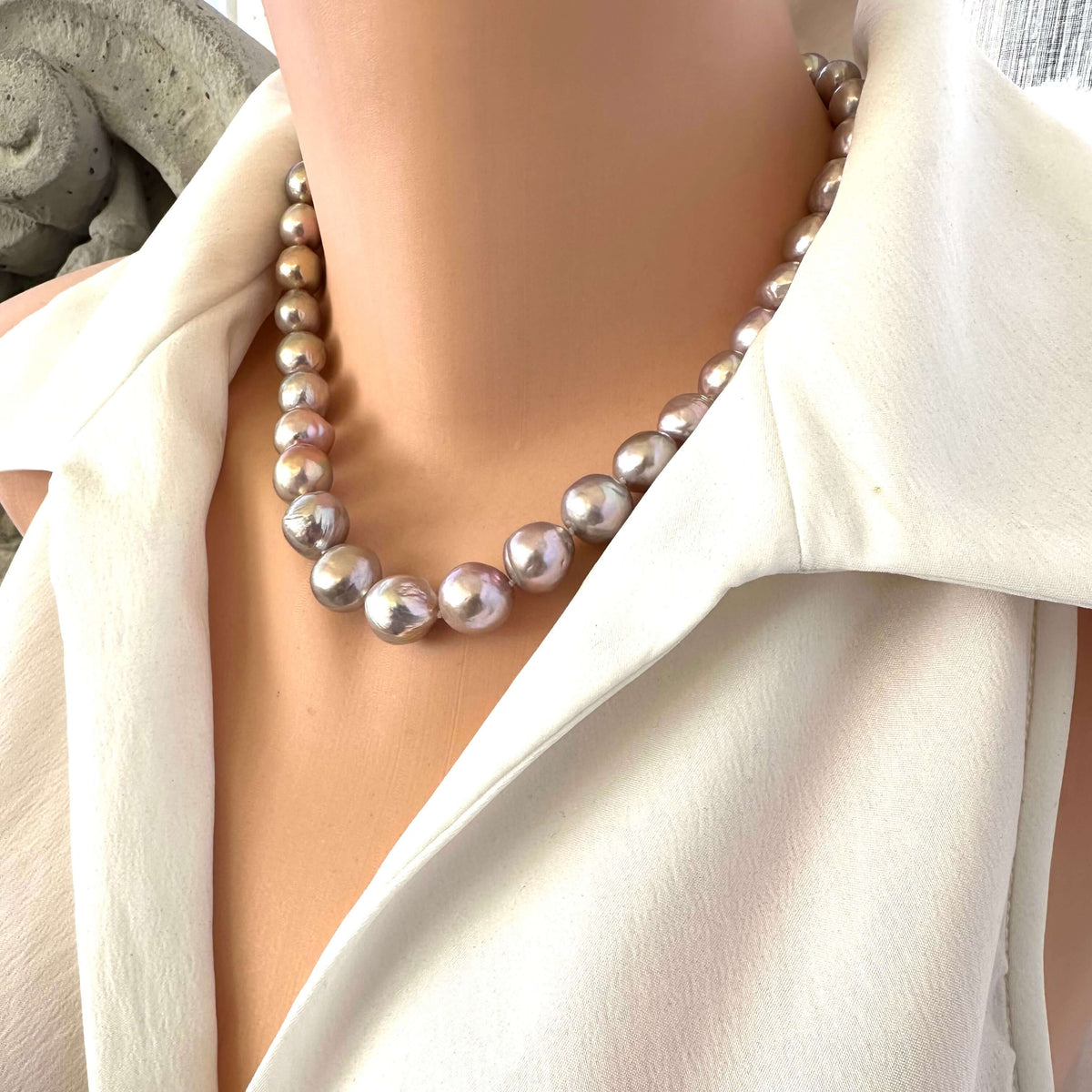 Pink lavender pearl necklace worn on mannequin, showing Edison baroque pearls with metallic luster and handcrafted knotting.