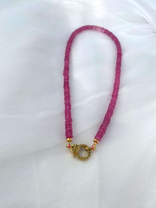 Pink topaz beaded necklace with gold vermeil pavé clasp displayed on a white surface.