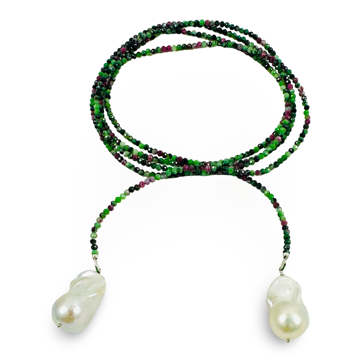 A long strand beaded necklace featuring vibrant green and deep purple beads, with two large, irregular white baroque pearls hanging from the ends, set against a plain white background.