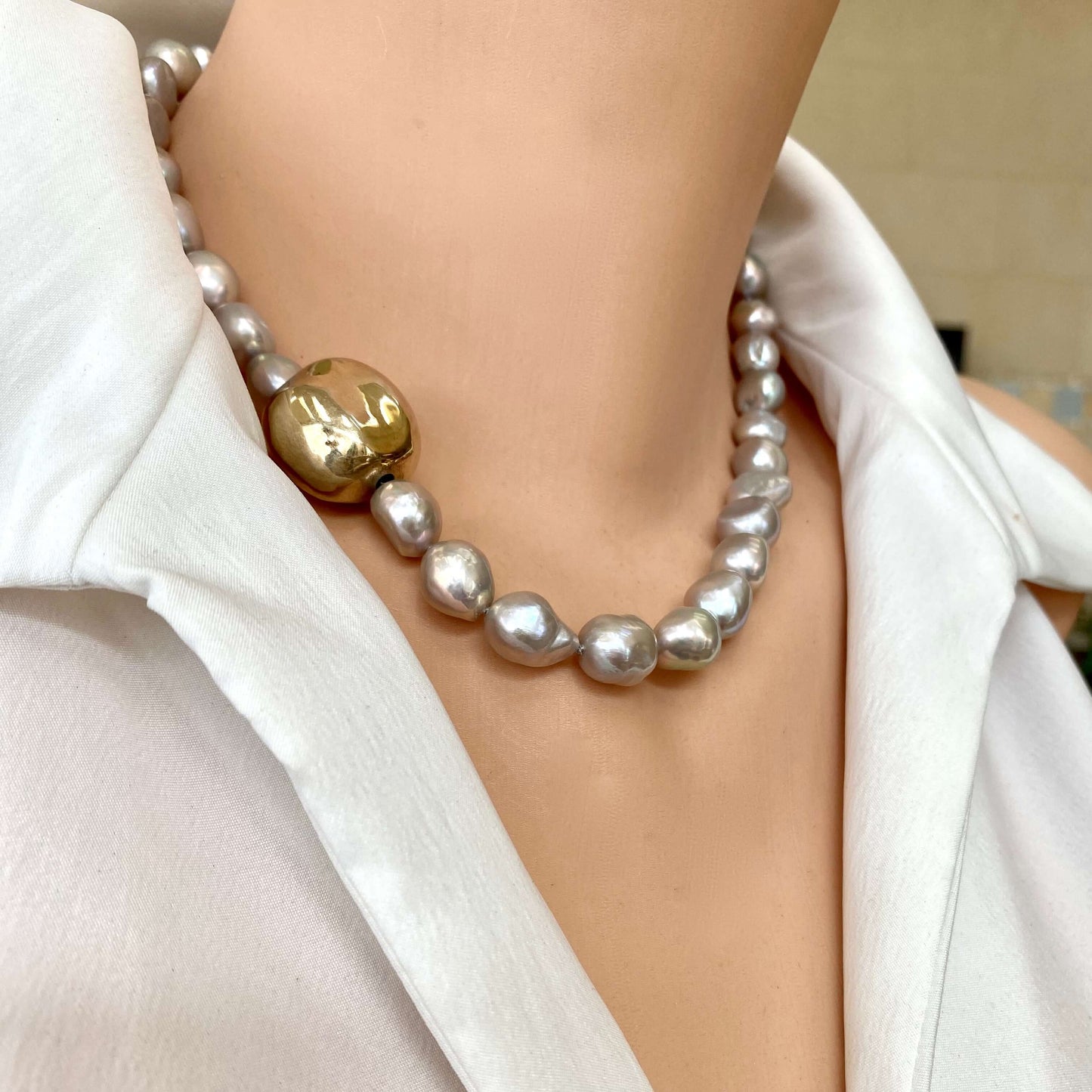 Grey pearl necklace with gold marine clasp styled close to neckline with luminous grey pearls