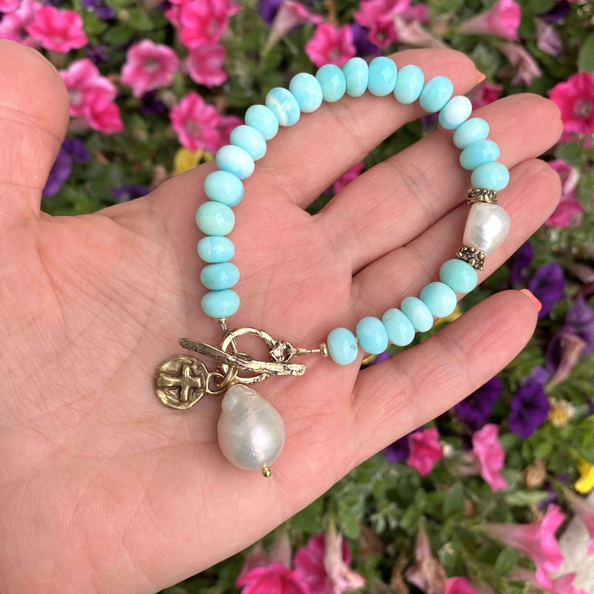 Sky blue opal bracelet with baroque pearls and cross charm, handcrafted with luminous rondelle beads.