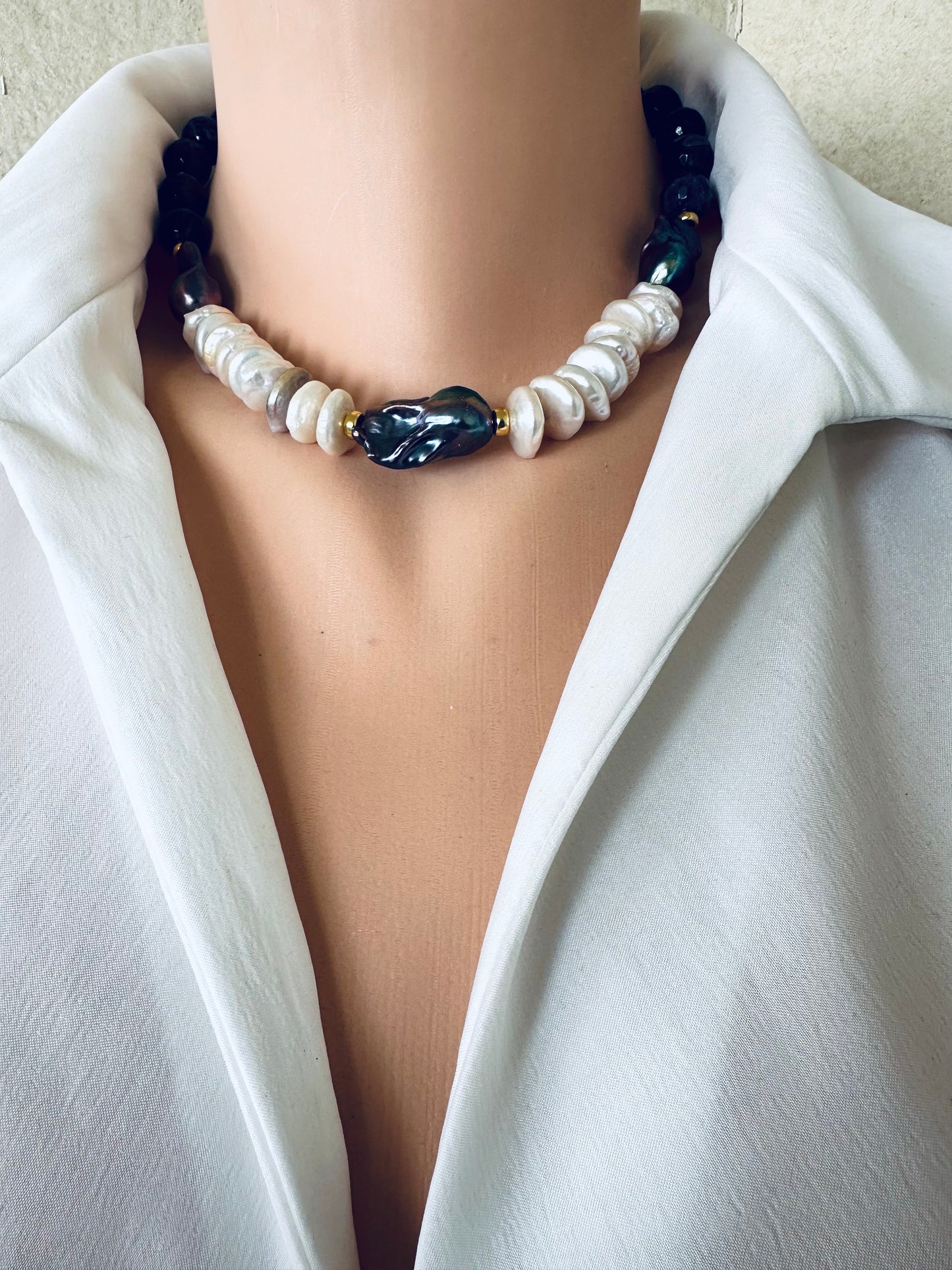 Baroque pearl necklace with purple amethyst beads and peacock black pearls worn at collarbone