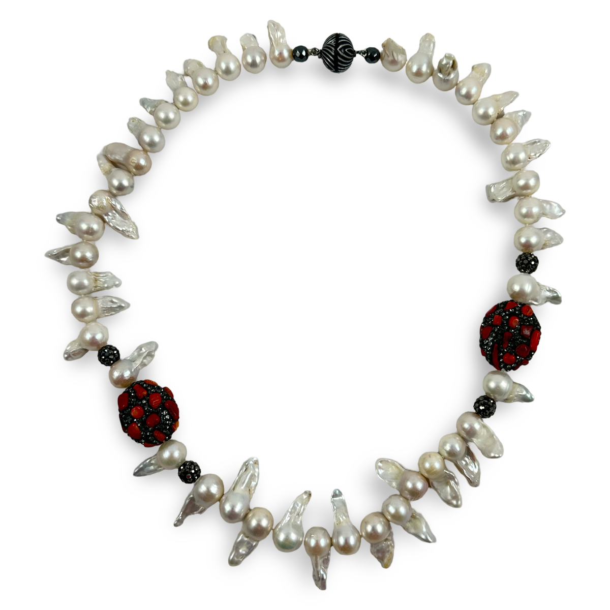 A baroque pearl necklace with irregular white pearls, silver-toned metal spacers, and two prominent red and black patterned round beads, shown on a plain white background.