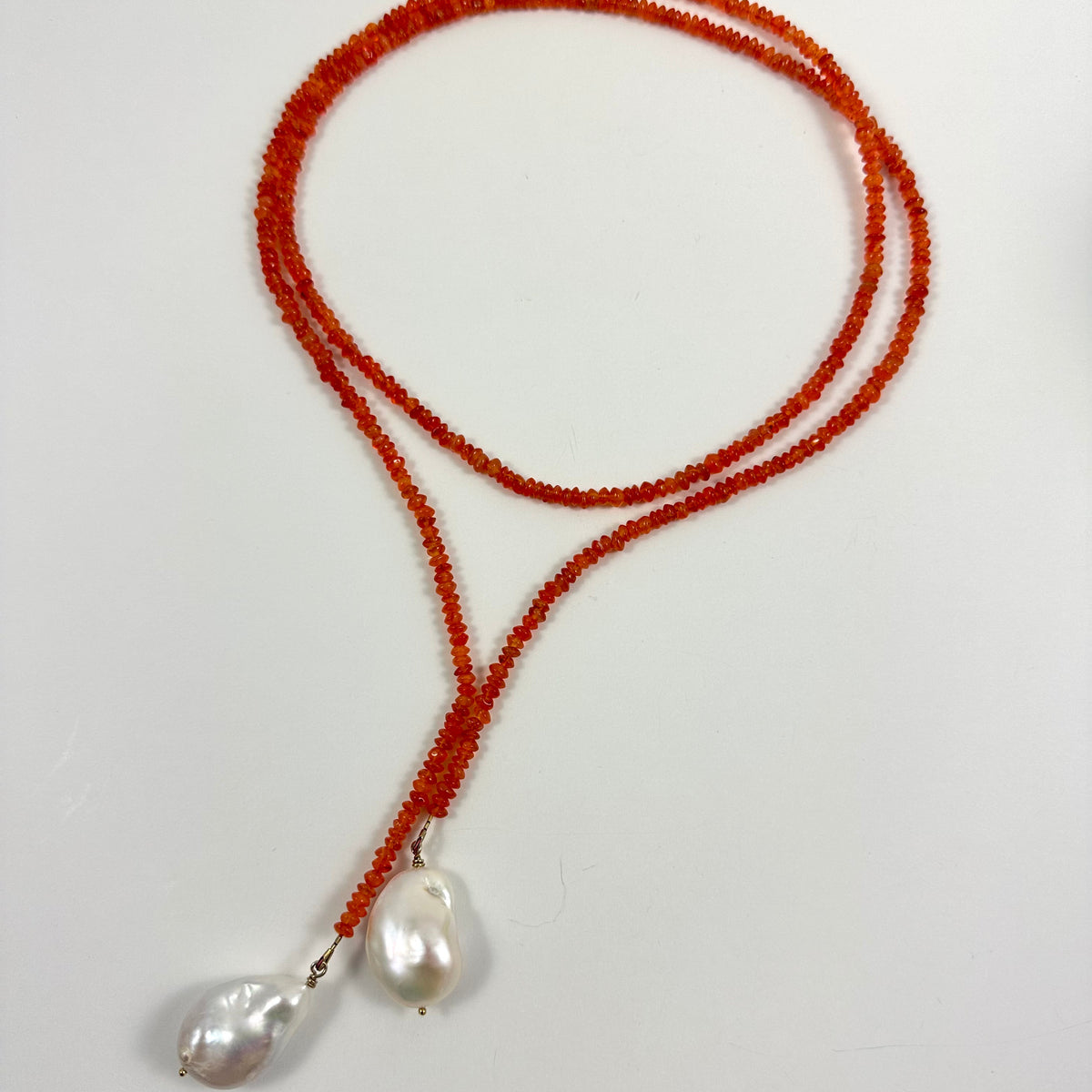 burnt orange beaded lariat-style necklace with two large baroque pearls,