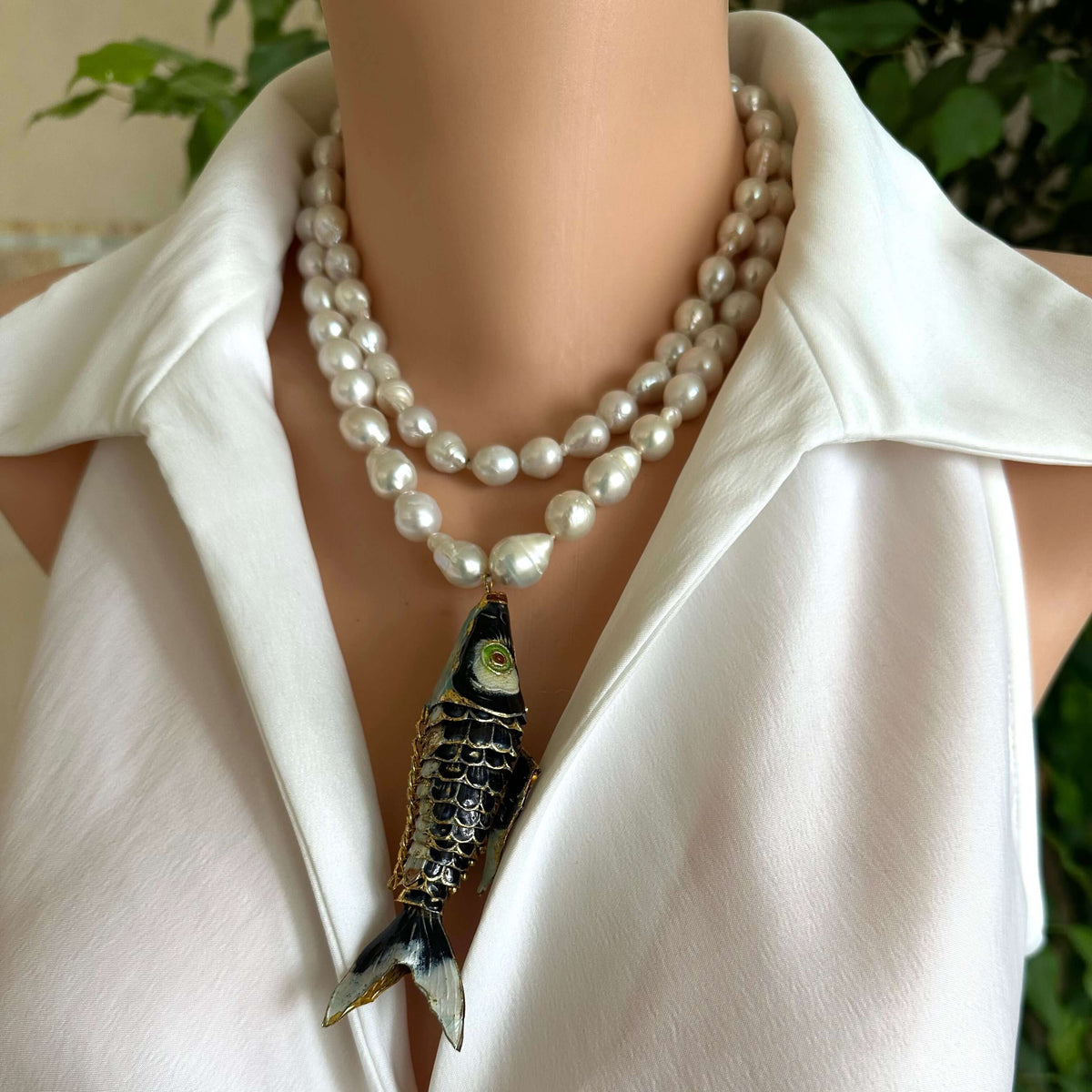 Fish pendant pearl necklace featuring a large cloisonné fish pendant and hand knotted baroque pearls.