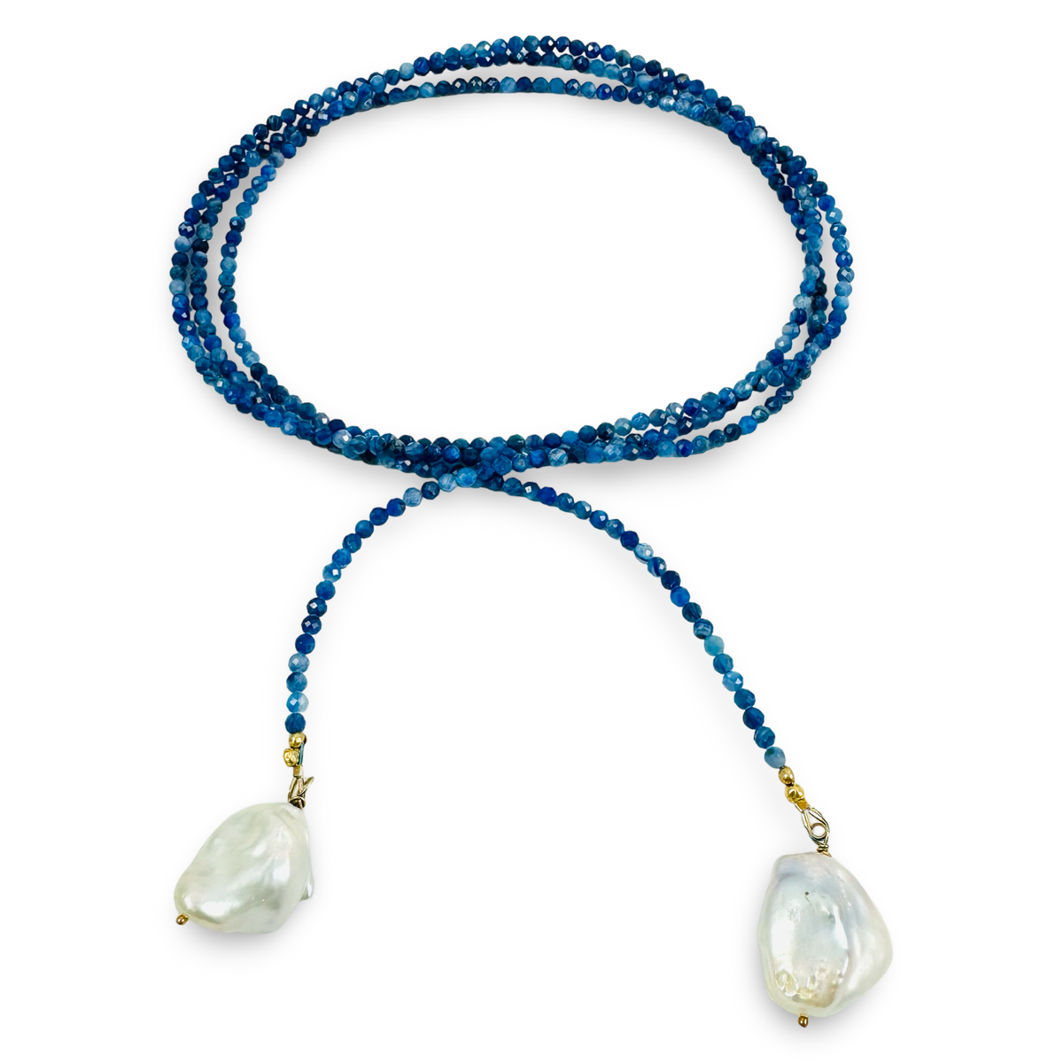 A beaded necklace featuring long strand of deep blue beads, and two large, irregular white baroque shell pendants, displayed on a clean white background.