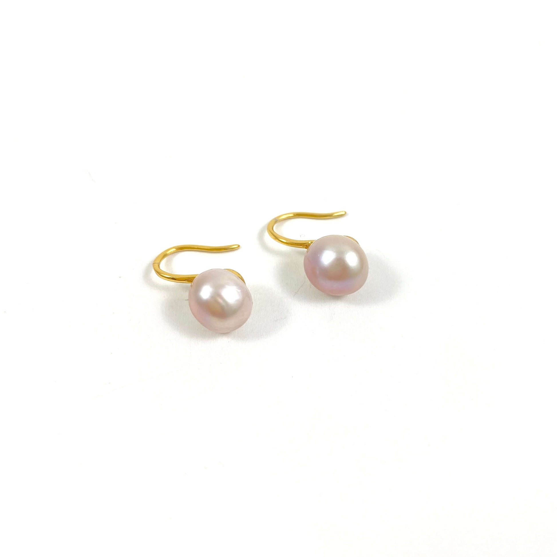 gold high heel earrings with pink pearls on white background