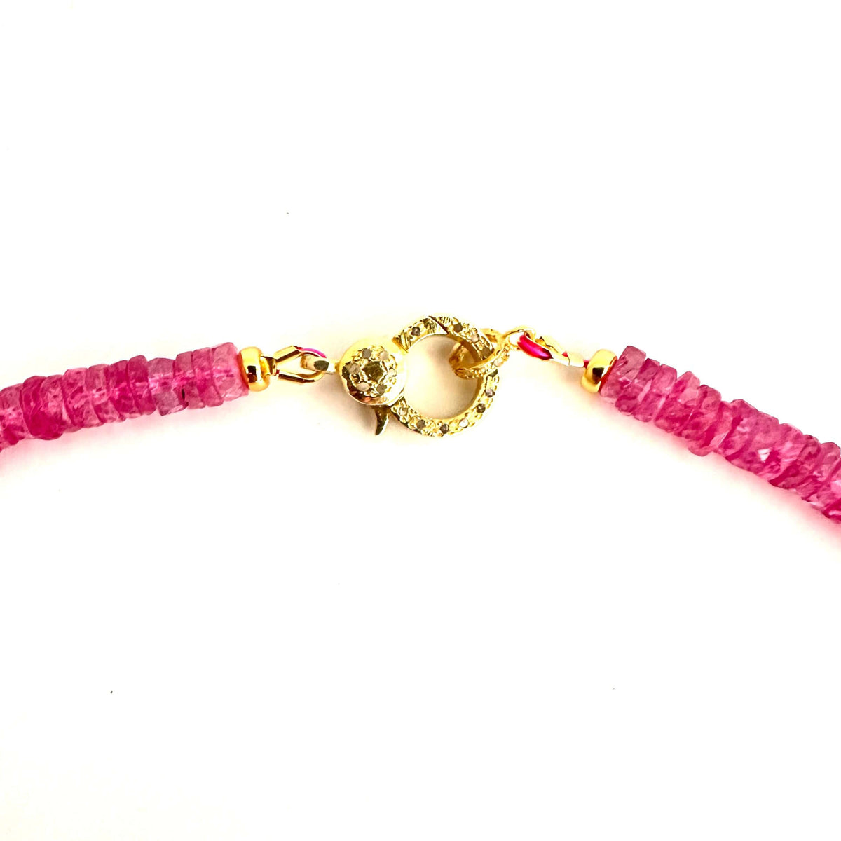 A close-up of a necklace with bright pink faceted gemstone beads and a gold-toned lobster clasp on a plain white background.