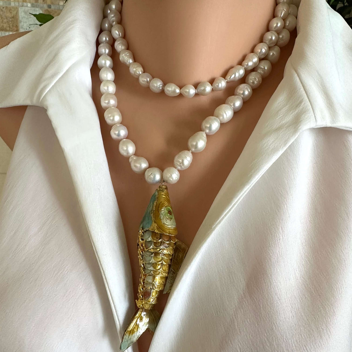 Baroque pearl necklace with fish pendant showcasing hand-knotted white baroque pearls and a stunning fish charm.
