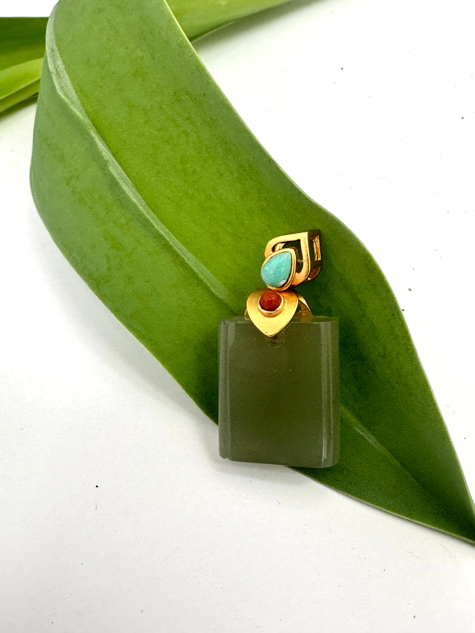 green pendant on a green leaf