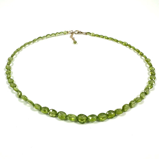 A beaded necklace made of faceted olive green beads with a small gold-tone clasp, displayed on a clean white background.