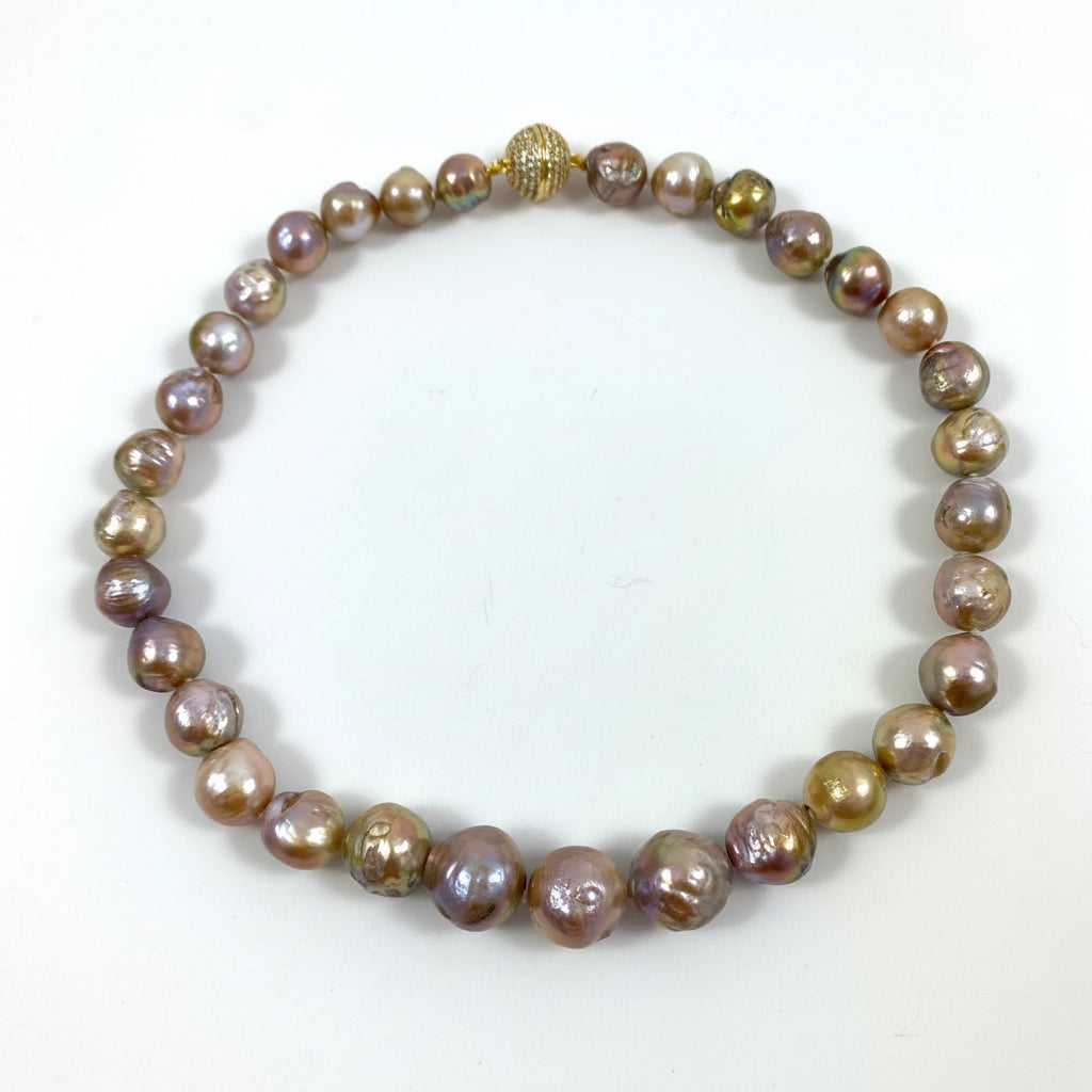 A beaded necklace made of irregular, lustrous baroque pearls in shades of bronze, gold, and muted purple, accented by a small textured gold bead at the top, displayed on a plain white background.