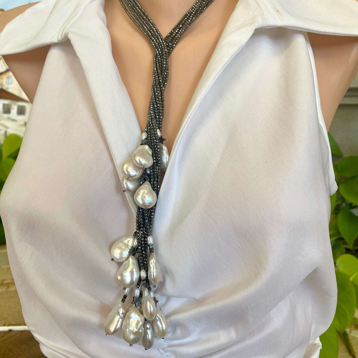 Hematite baroque pearl lariat necklace styled long on model with star and pearl accents
