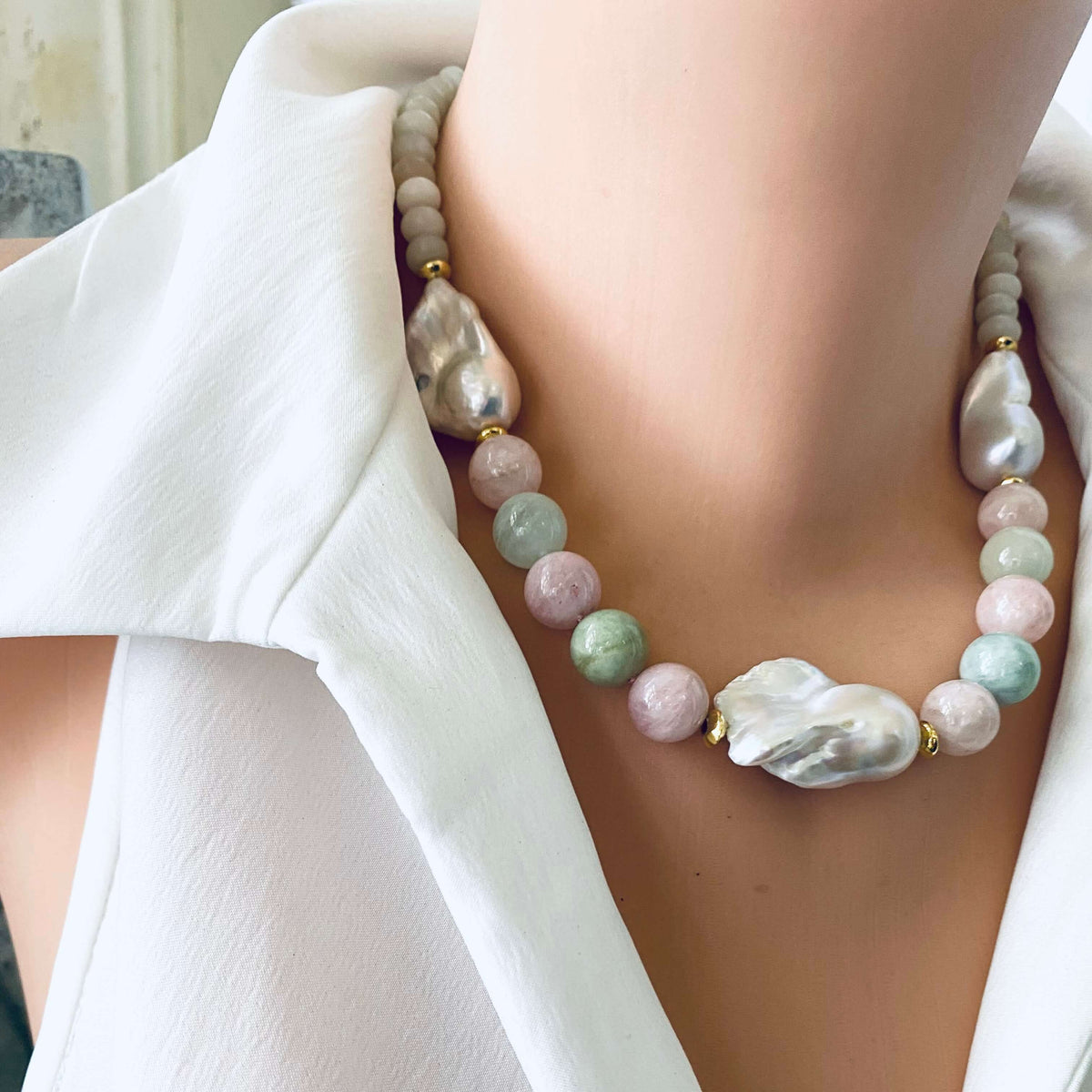 Close-up angled view of morganite and jade necklace with baroque pearls on mannequin, showing soft pink and green gemstones.