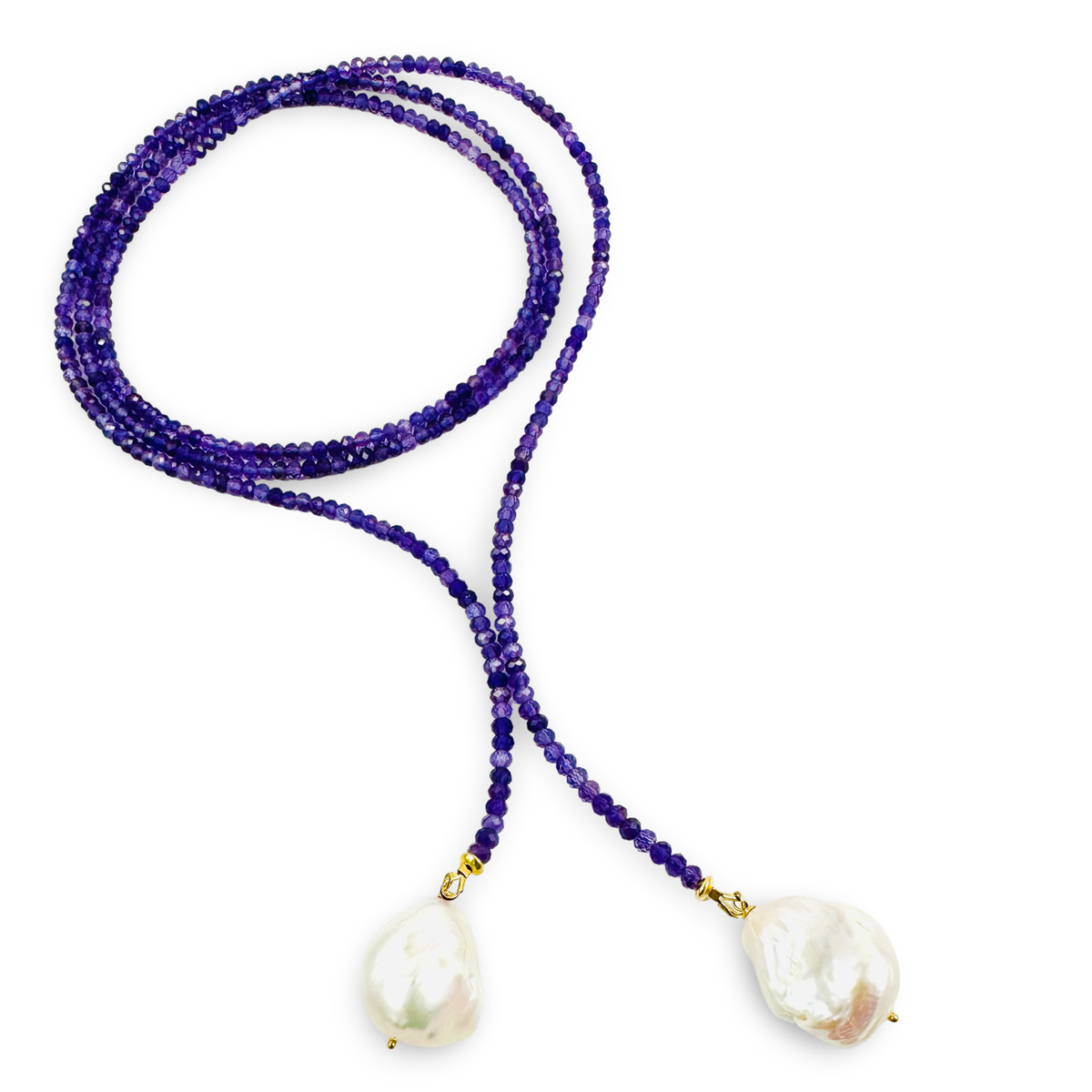 A long-strand beaded necklace featuring deep purple amethyst beads and two large, irregular white baroque pearls suspended from gold-toned metal rings, set against a plain white background.