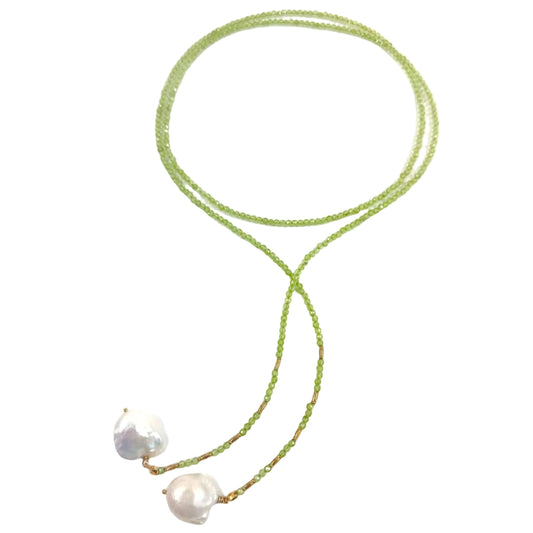 A delicate necklace featuring a fine green beaded chain with two large, irregular white baroque pearls at the end, displayed on a clean white background.